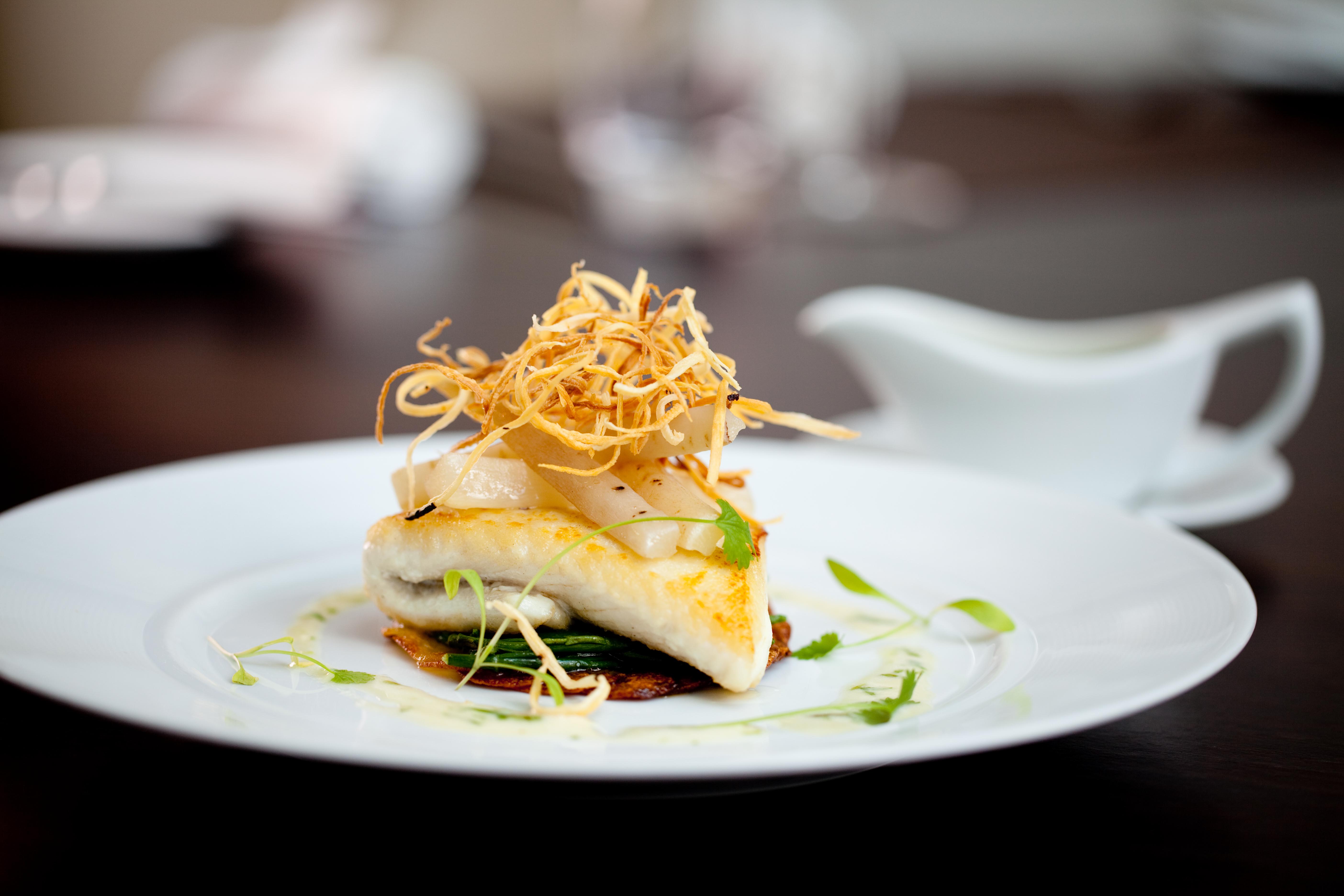 Elegant fish dish with crispy garnishes at Sofitel London Heathrow for upscale events.