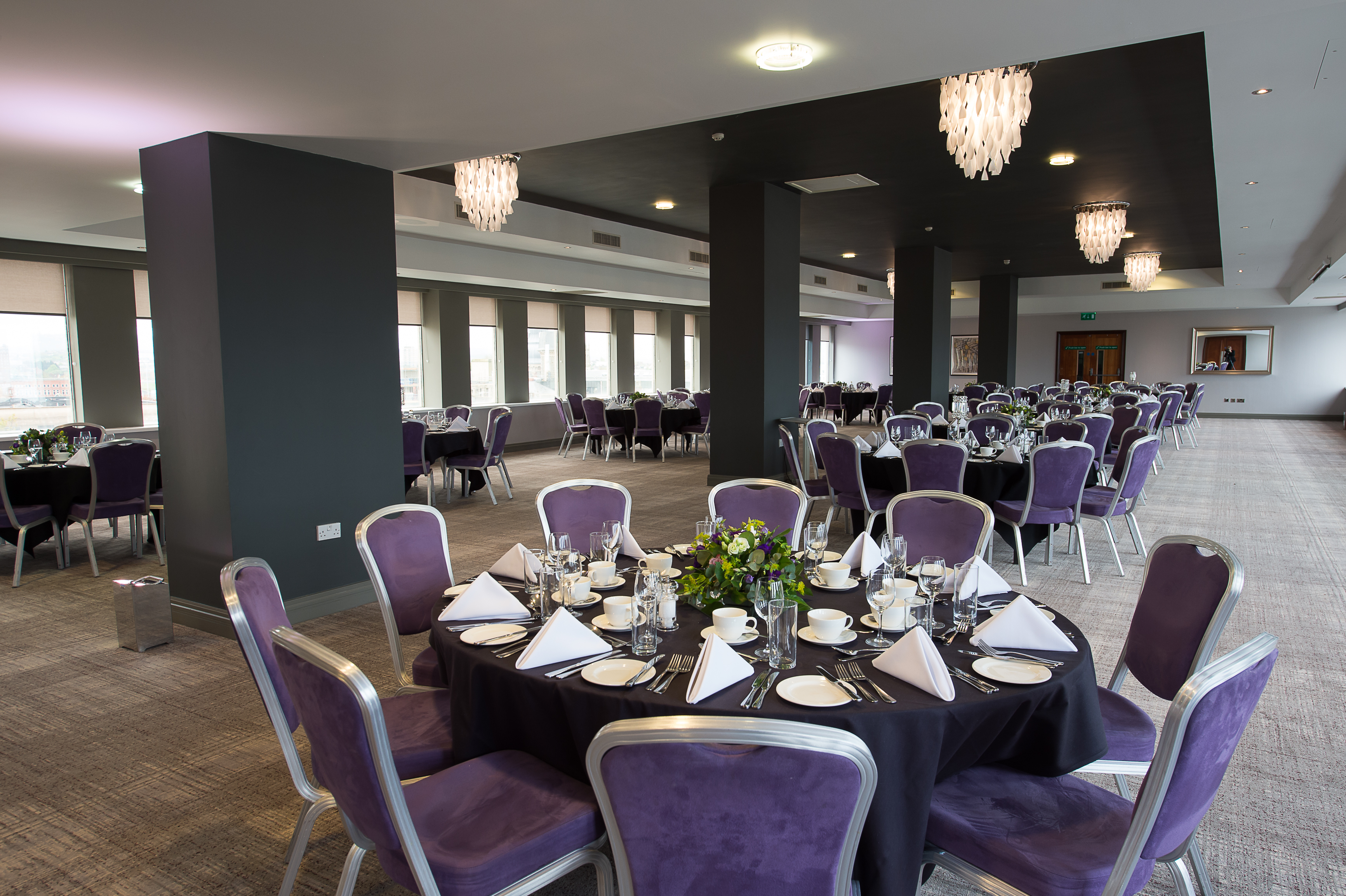 Elegant Forest Suite event space with round tables, ideal for corporate gatherings.