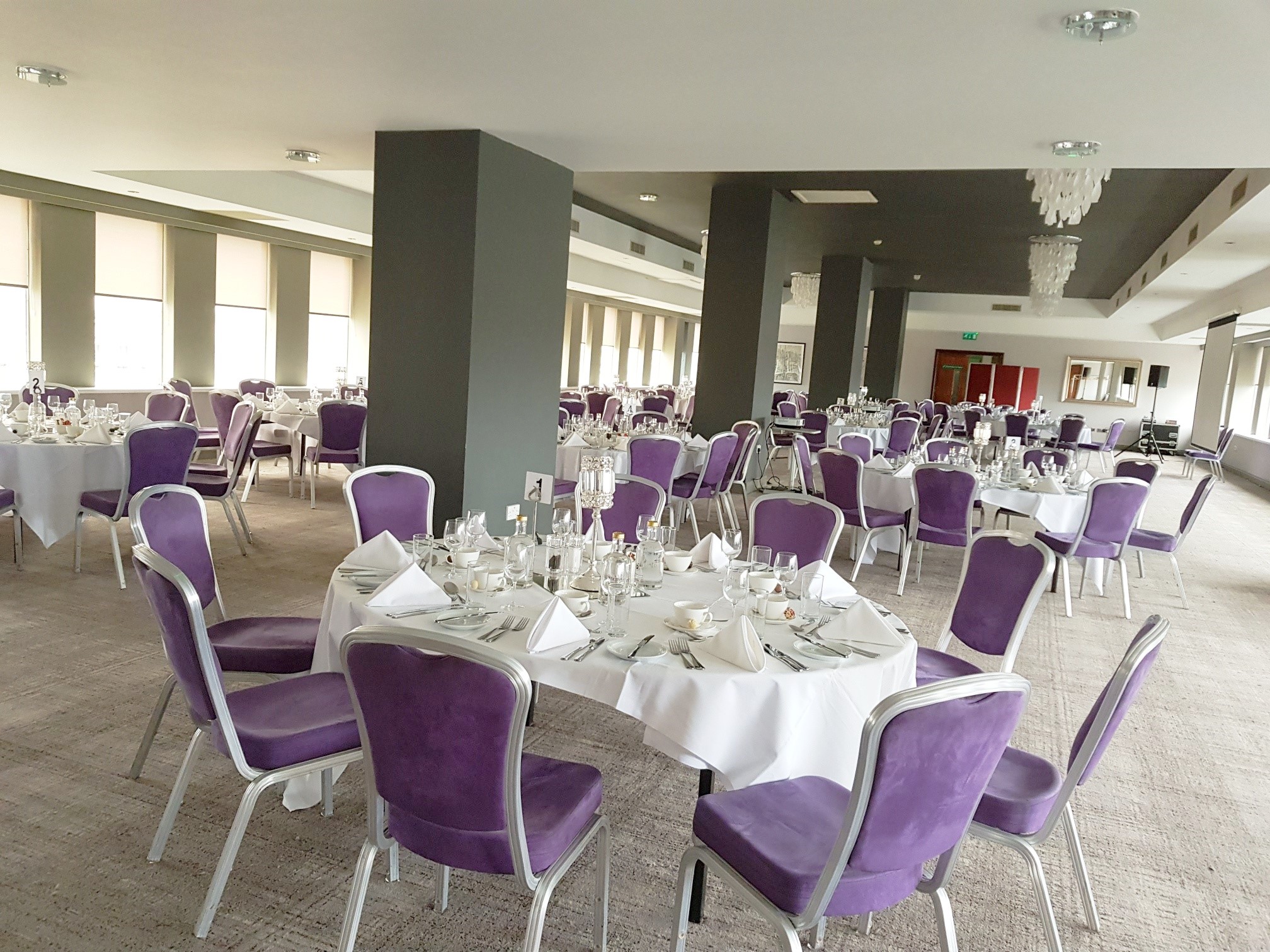 Forest Suite at Mercure Bristol: elegant event space with round tables and purple chairs.
