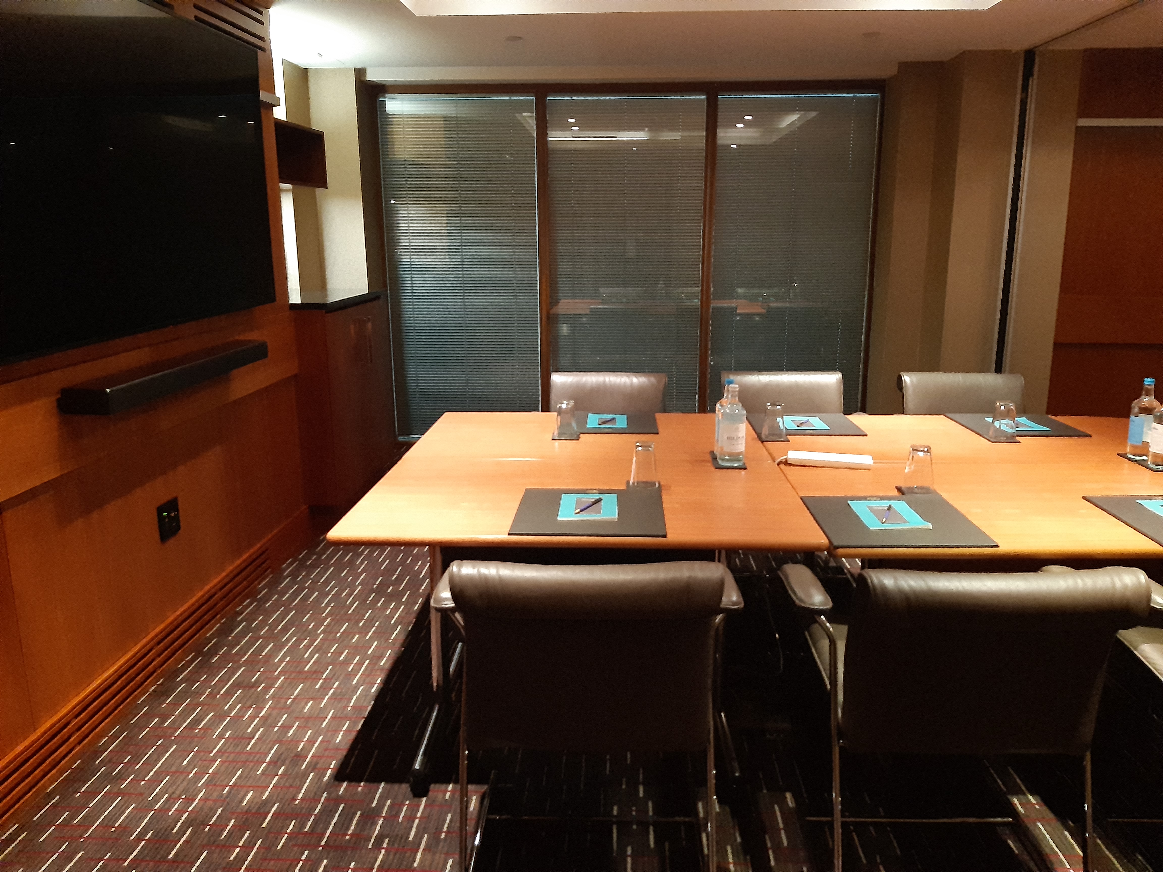 Meeting room at Sofitel London Heathrow with sleek wooden table for professional events.