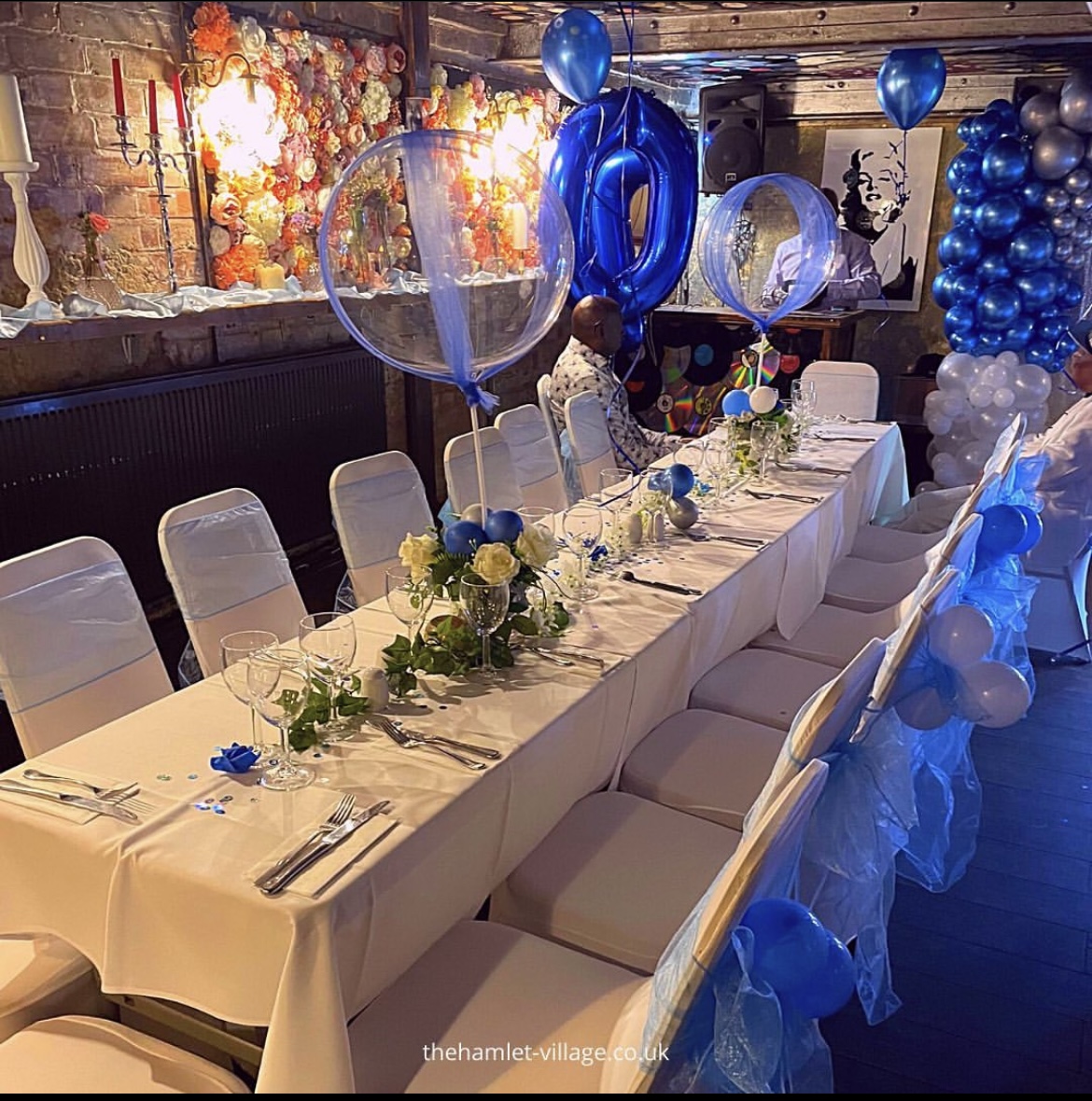 Elegant event space at The Hamlet Vinyl Bar with floral centerpieces and blue decor.