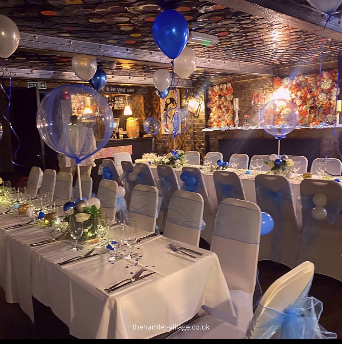 Elegant event space at The Hamlet Vinyl Bar with blue accents and festive decor.