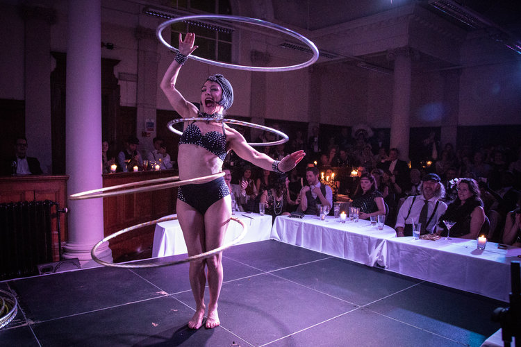 Hula hoop artist performing at The Candlelight Club event, enhancing guest experience.