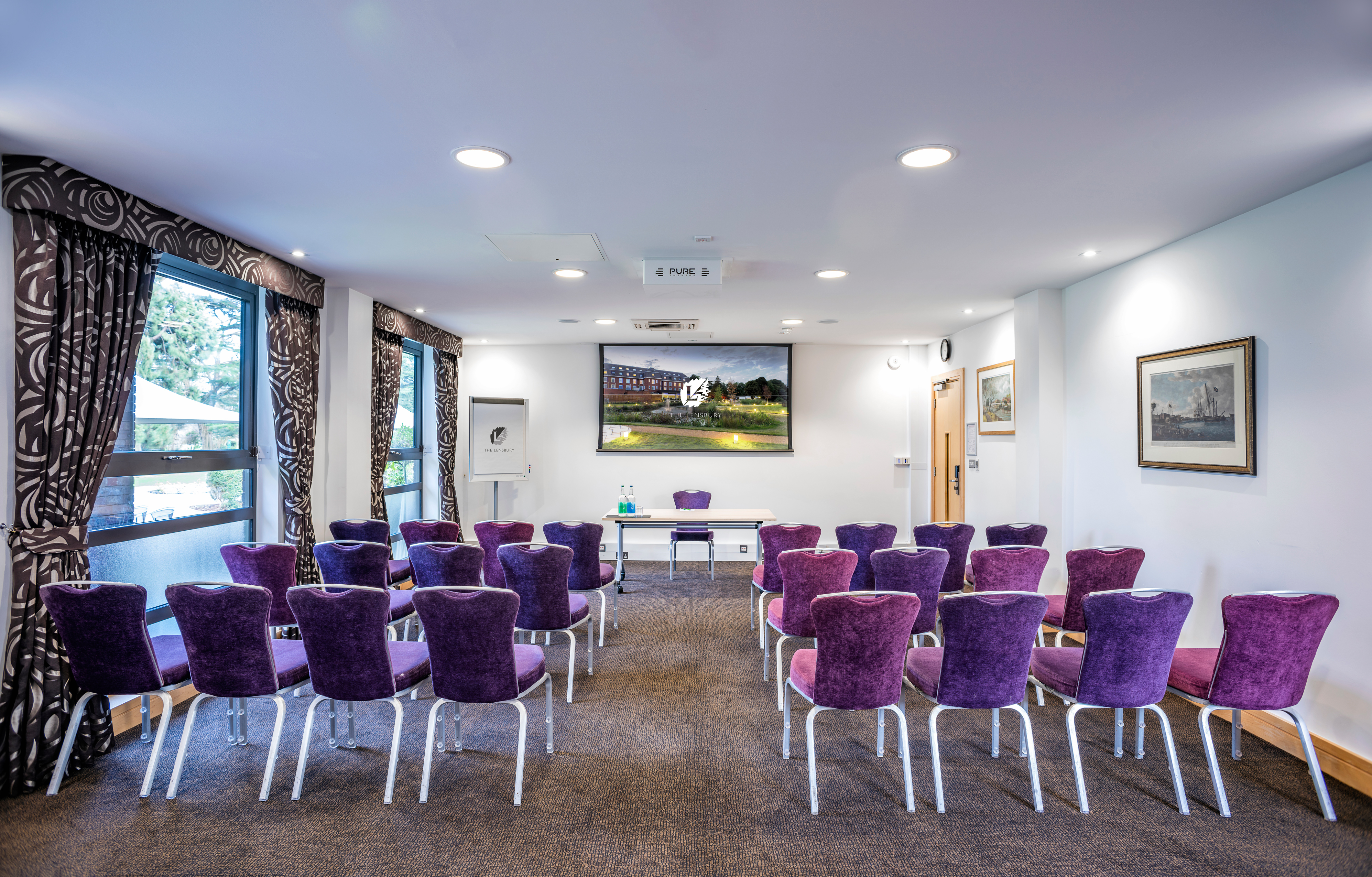 Mortimer Room at The Lensbury: elegant meeting space with purple chairs for presentations.