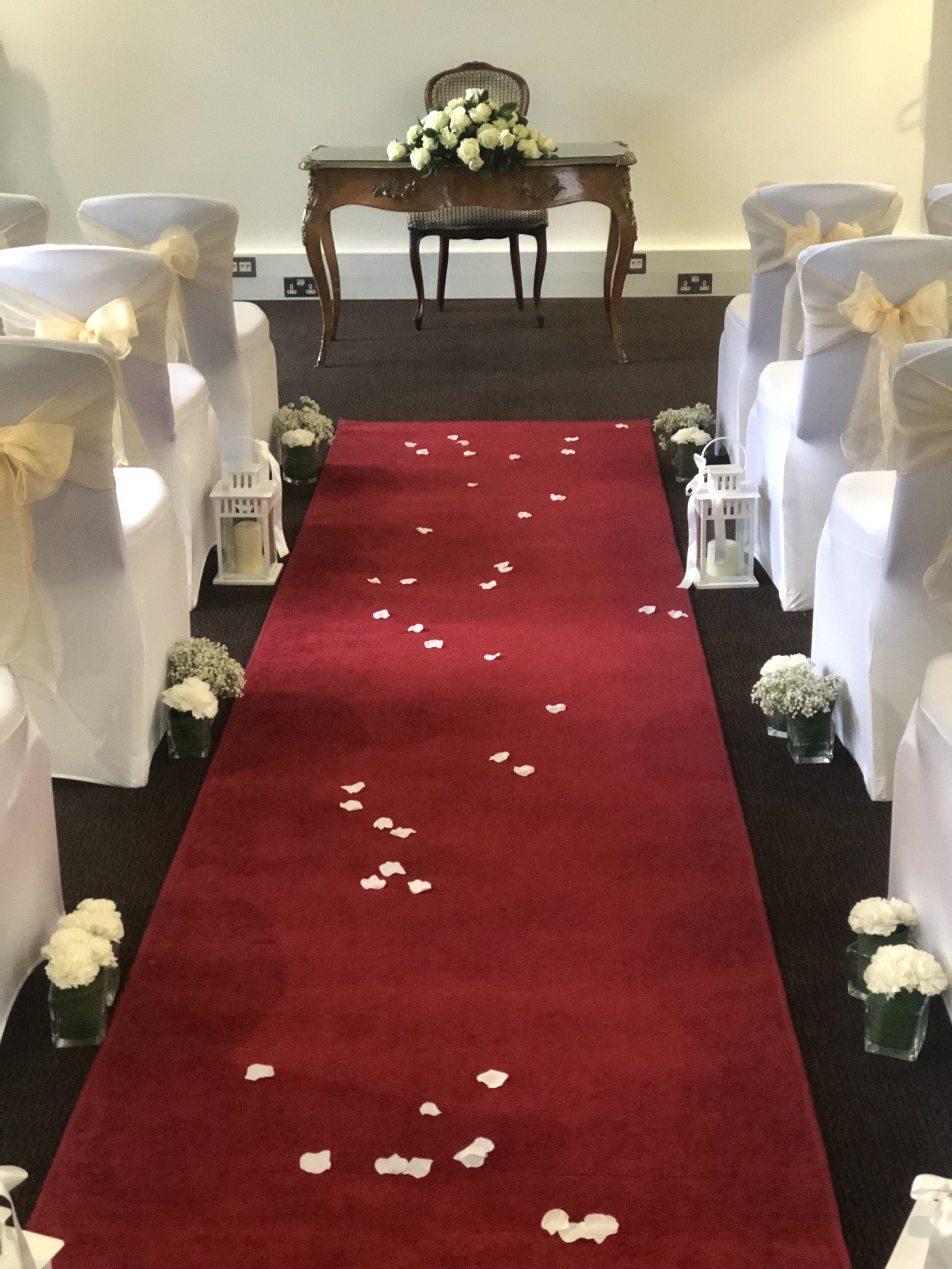 Mortimer Room wedding aisle with red carpet, flower petals, and elegant decor.