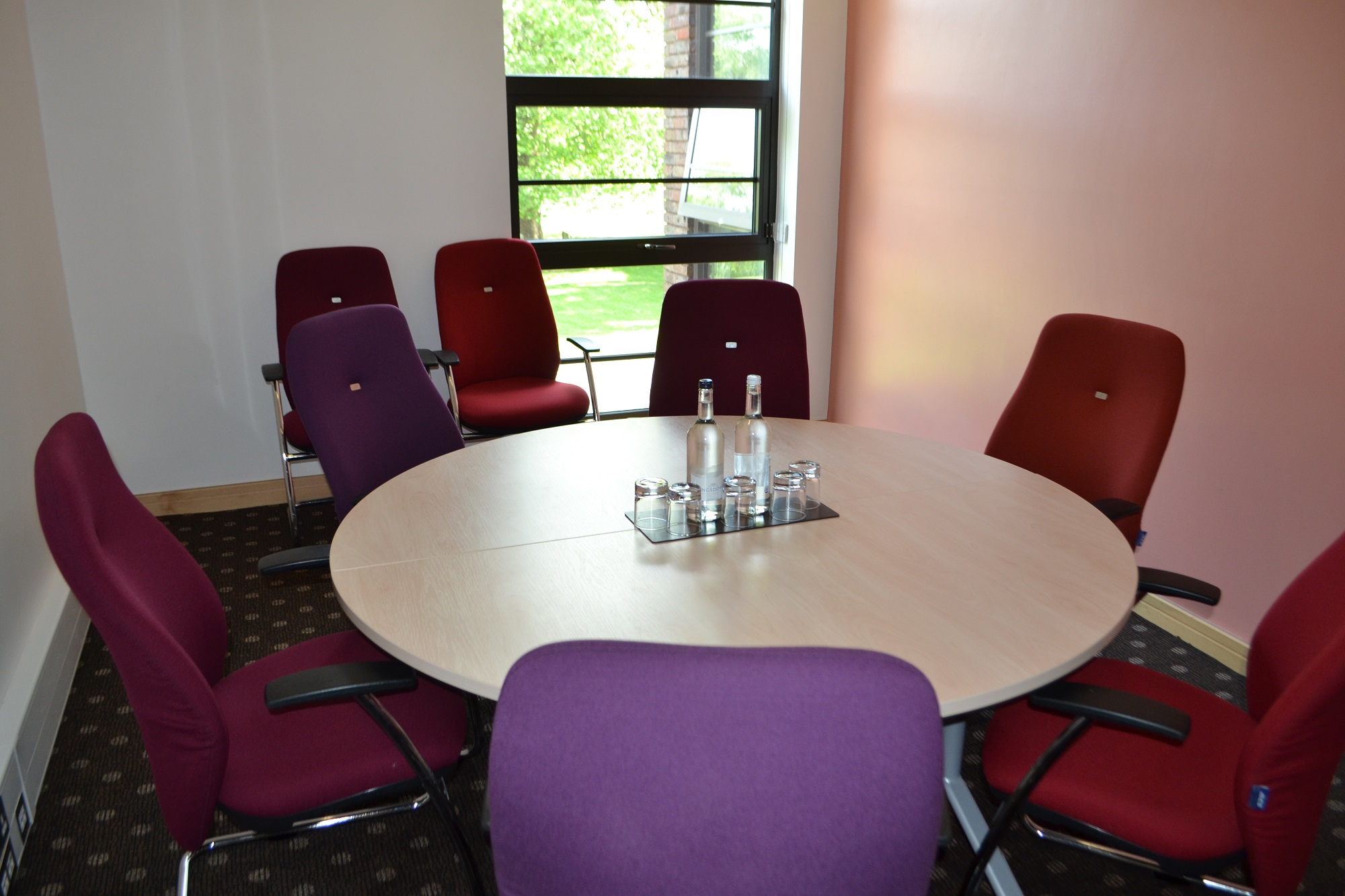 Syndicate Rooms at The Lensbury: bright meeting space with round table for collaborative sessions.