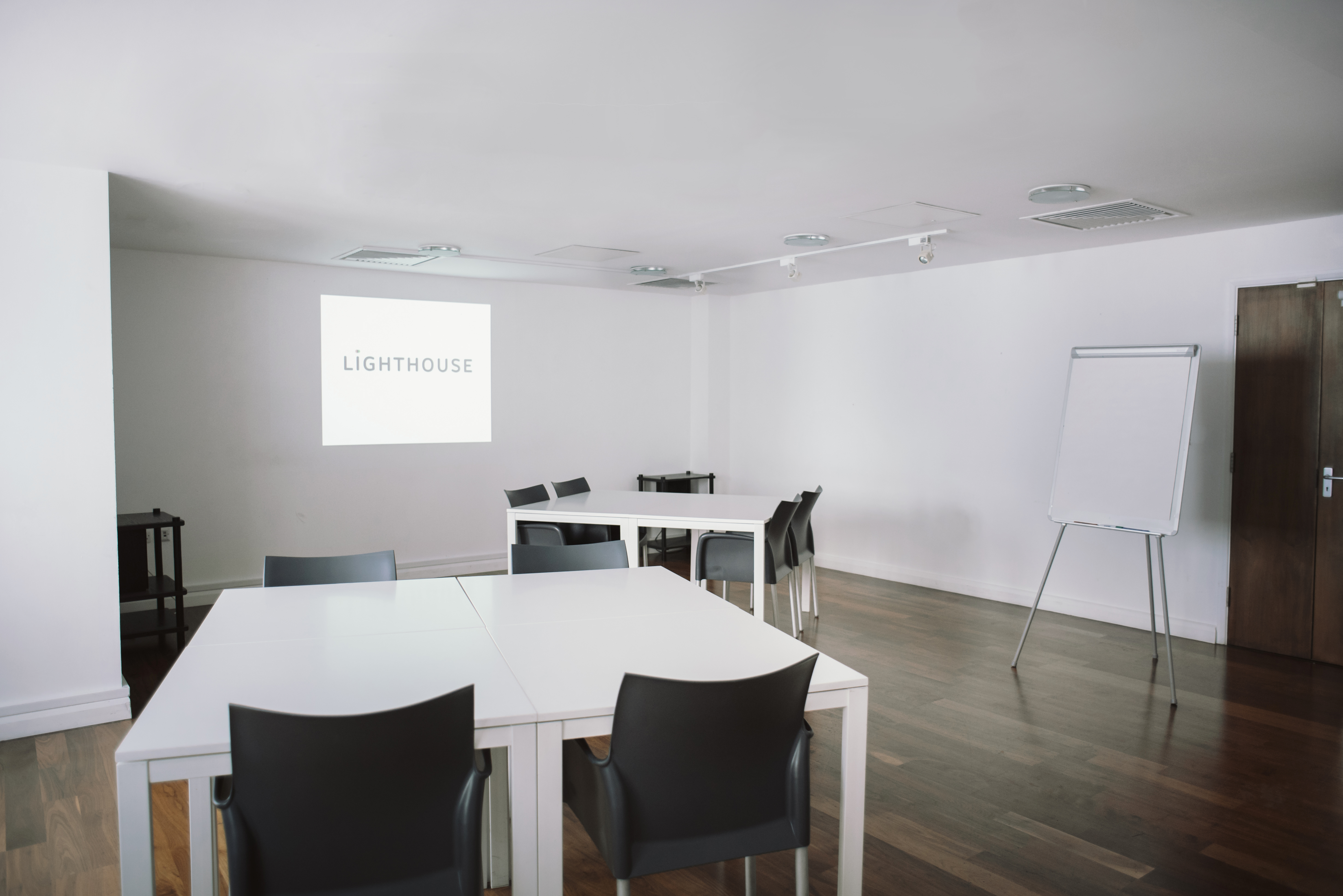 Modern conference room with projector screen, ideal for corporate meetings and workshops.