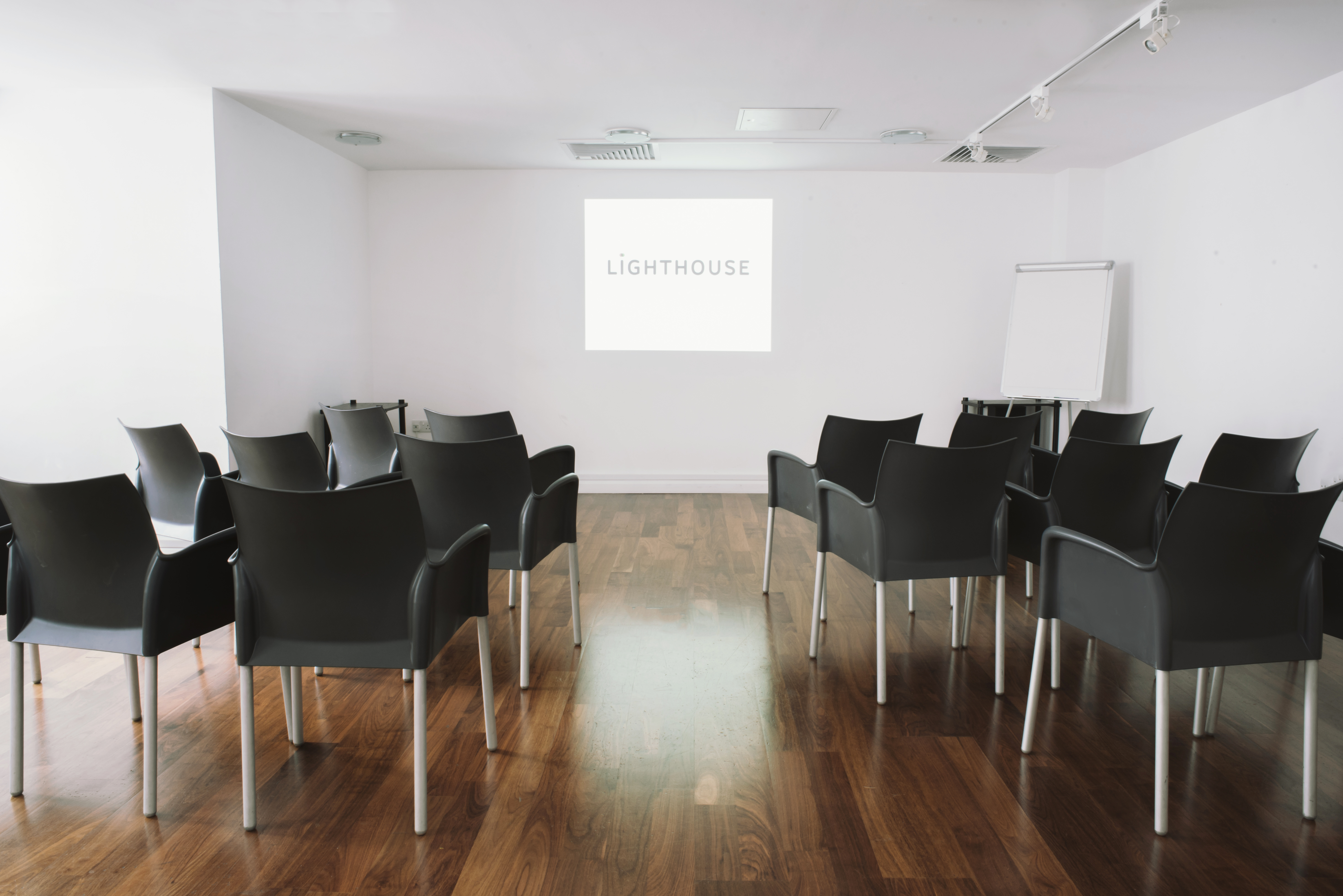 Minimalist conference room with black chairs for presentations and workshops.