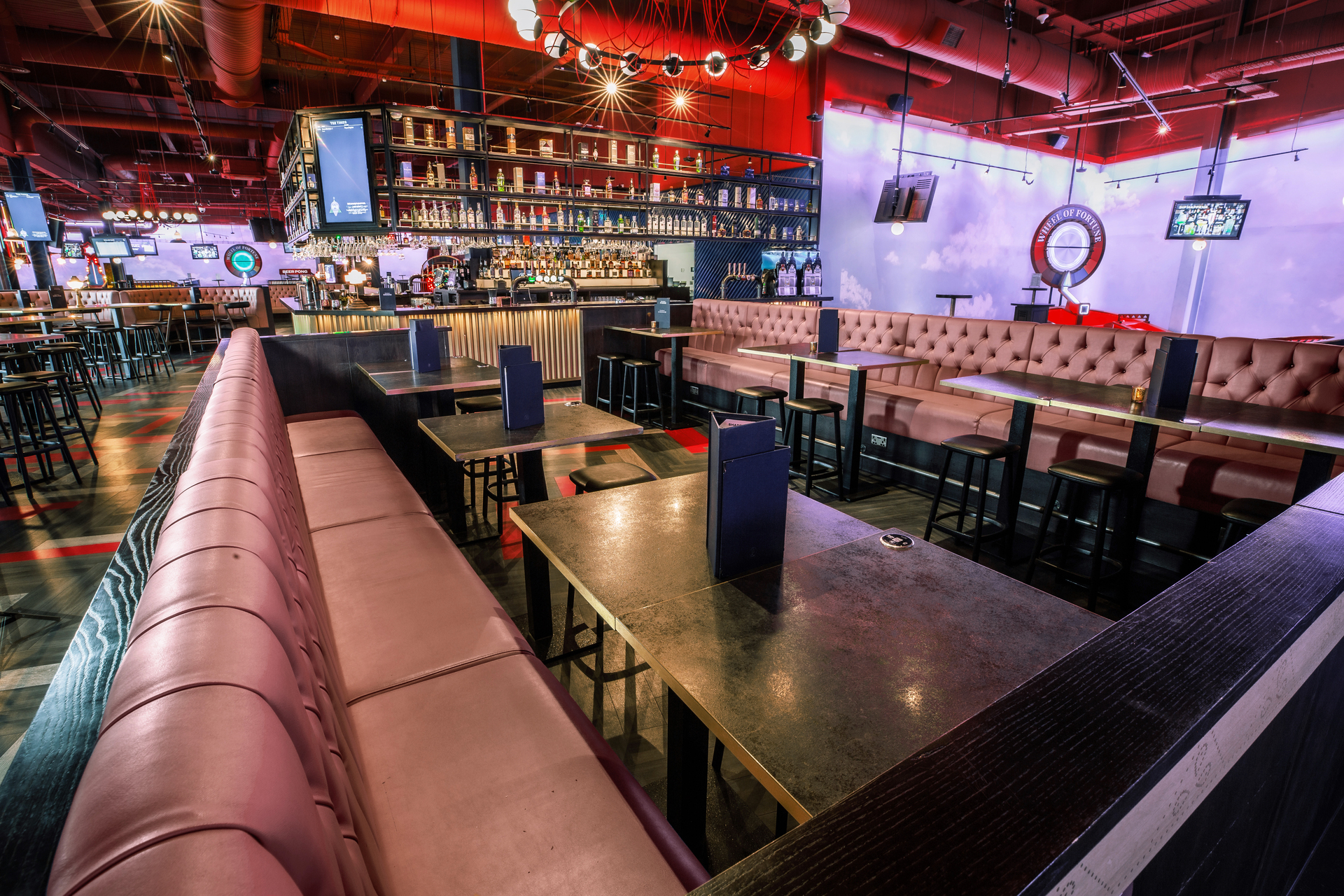 Violet semi-private event space at Puttshack Lakeside with stylish seating and vibrant bar.