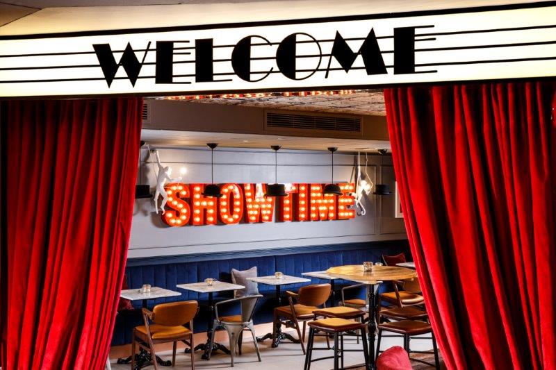 Vibrant event space in Ibis Styles Southwark with red curtains for gatherings and performances.