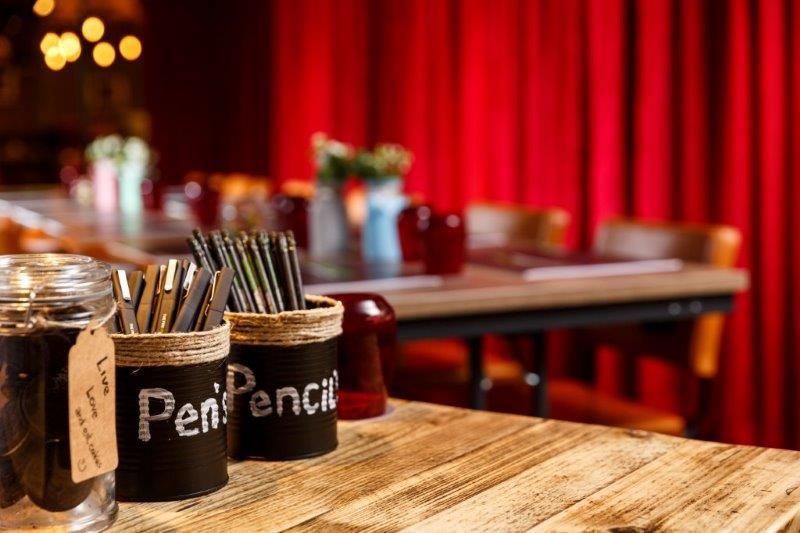 Meeting space at Dickens Club, Ibis Styles Southwark, with rustic table and vibrant decor.