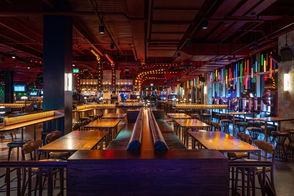 "Vibrant Christmas event space at Puttshack White City with modern design and seating."