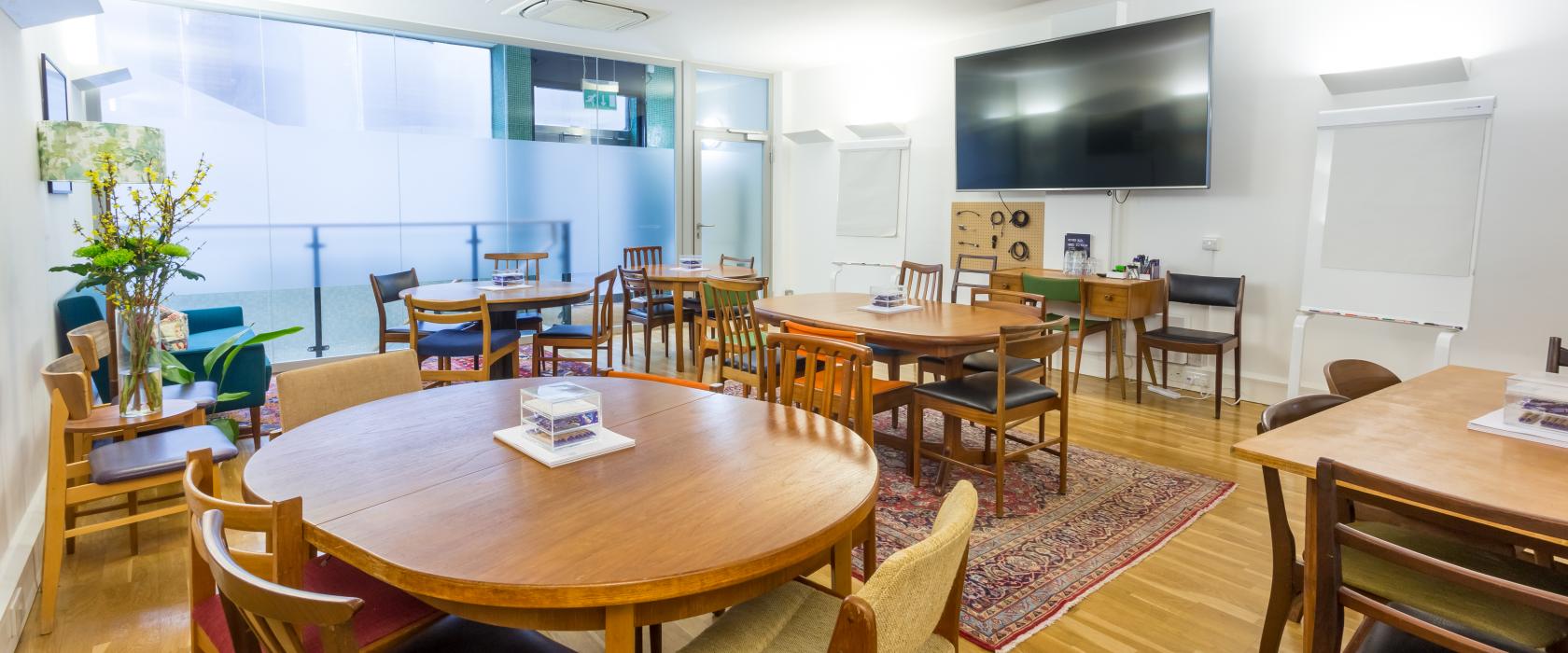 Versatile meeting space with round tables, ideal for workshops and conferences.