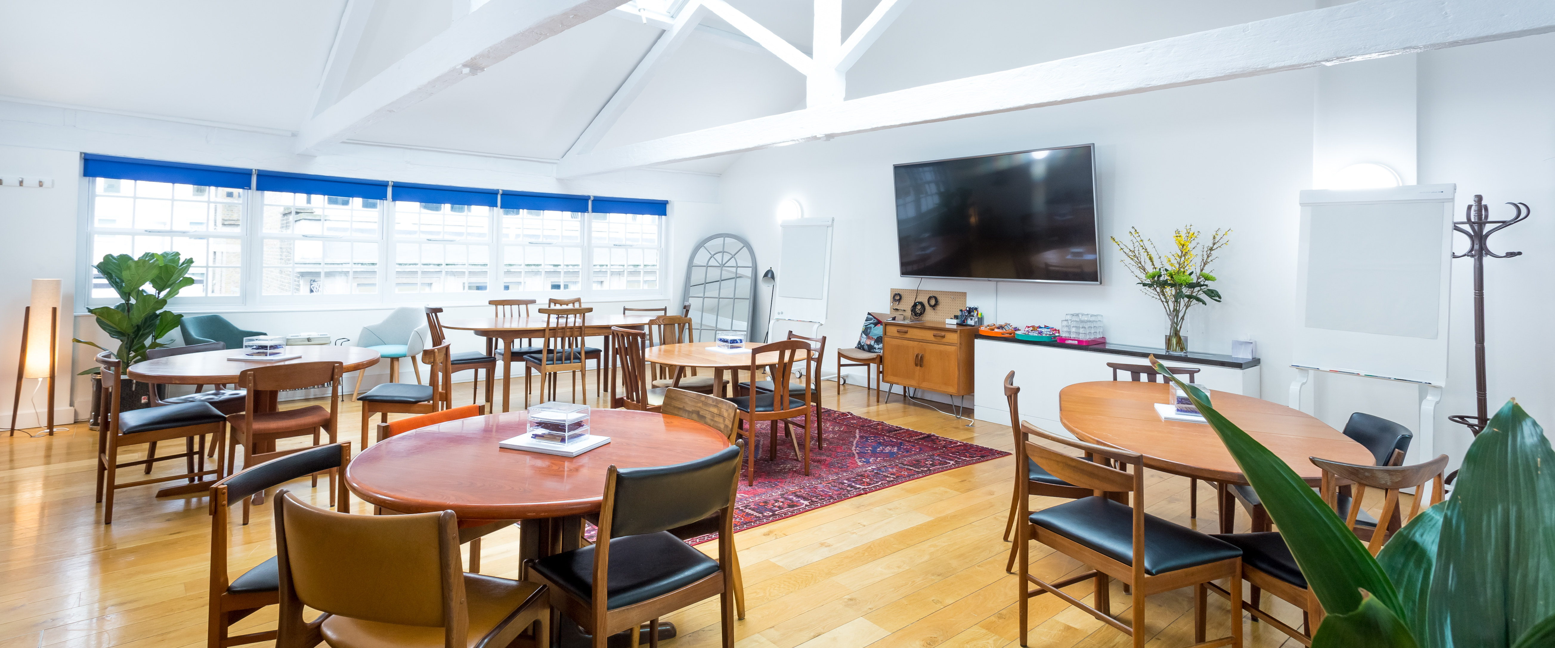 Versatile meeting space with round tables and large screen at Wallacespace Covent Garden.