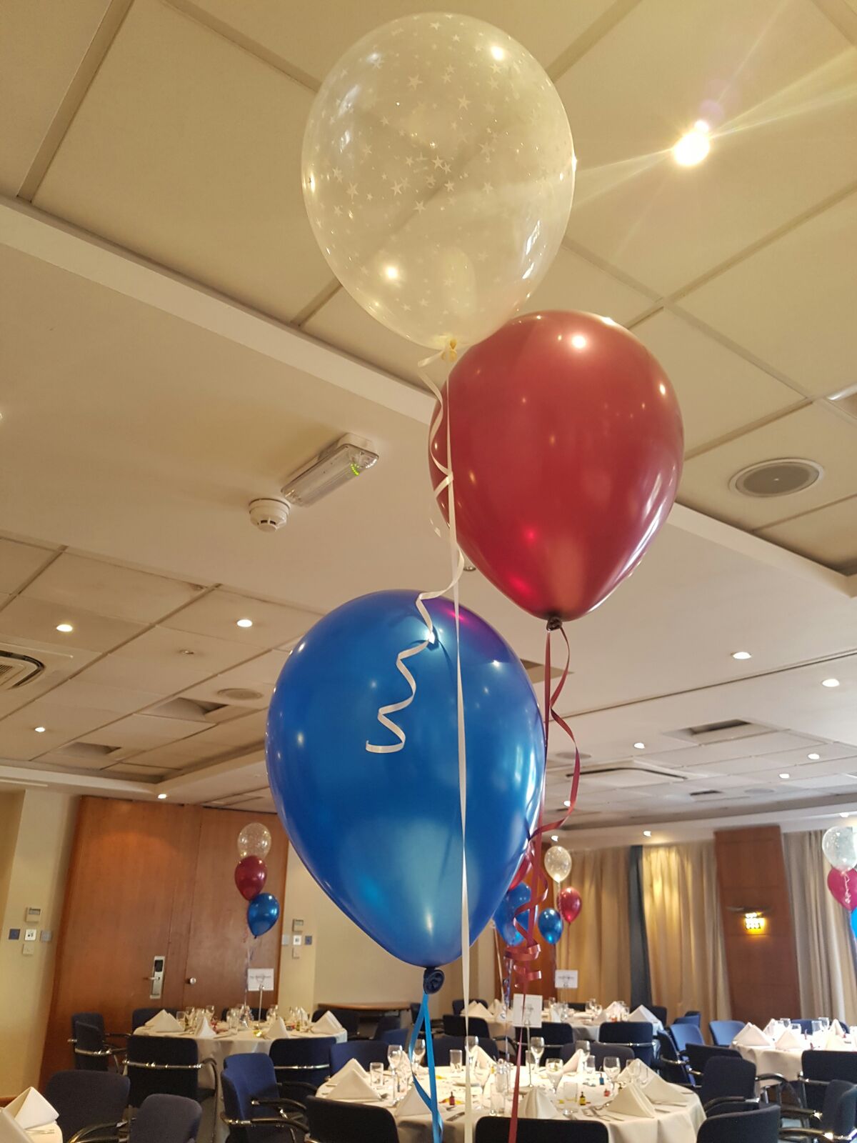 Vibrant blue and red balloons in Holiday Inn High Wycombe for a festive event.