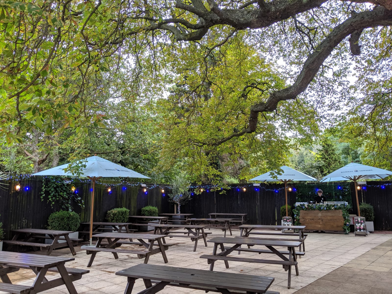 "Inviting outdoor garden venue with shaded seating for casual events and gatherings"