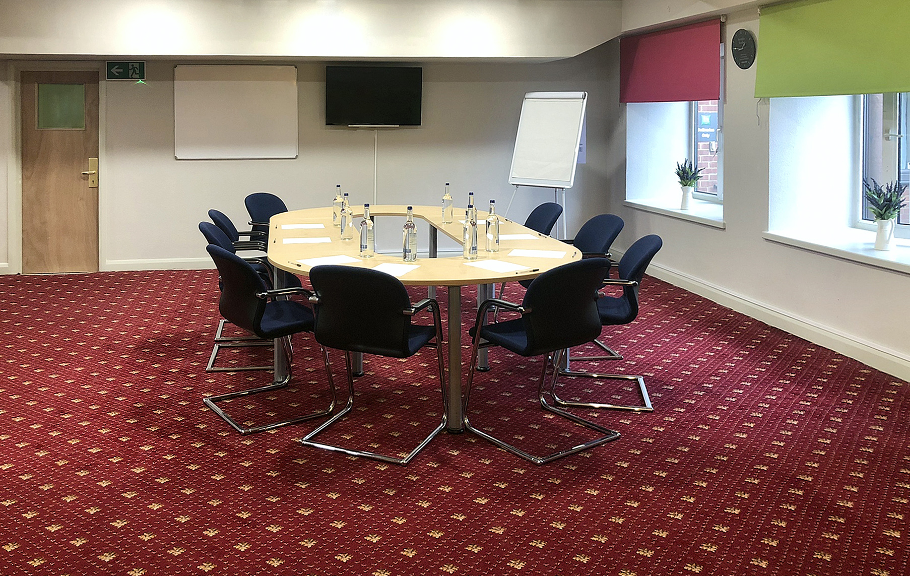 Meeting room with oval table, ideal for collaborative meetings and presentations.