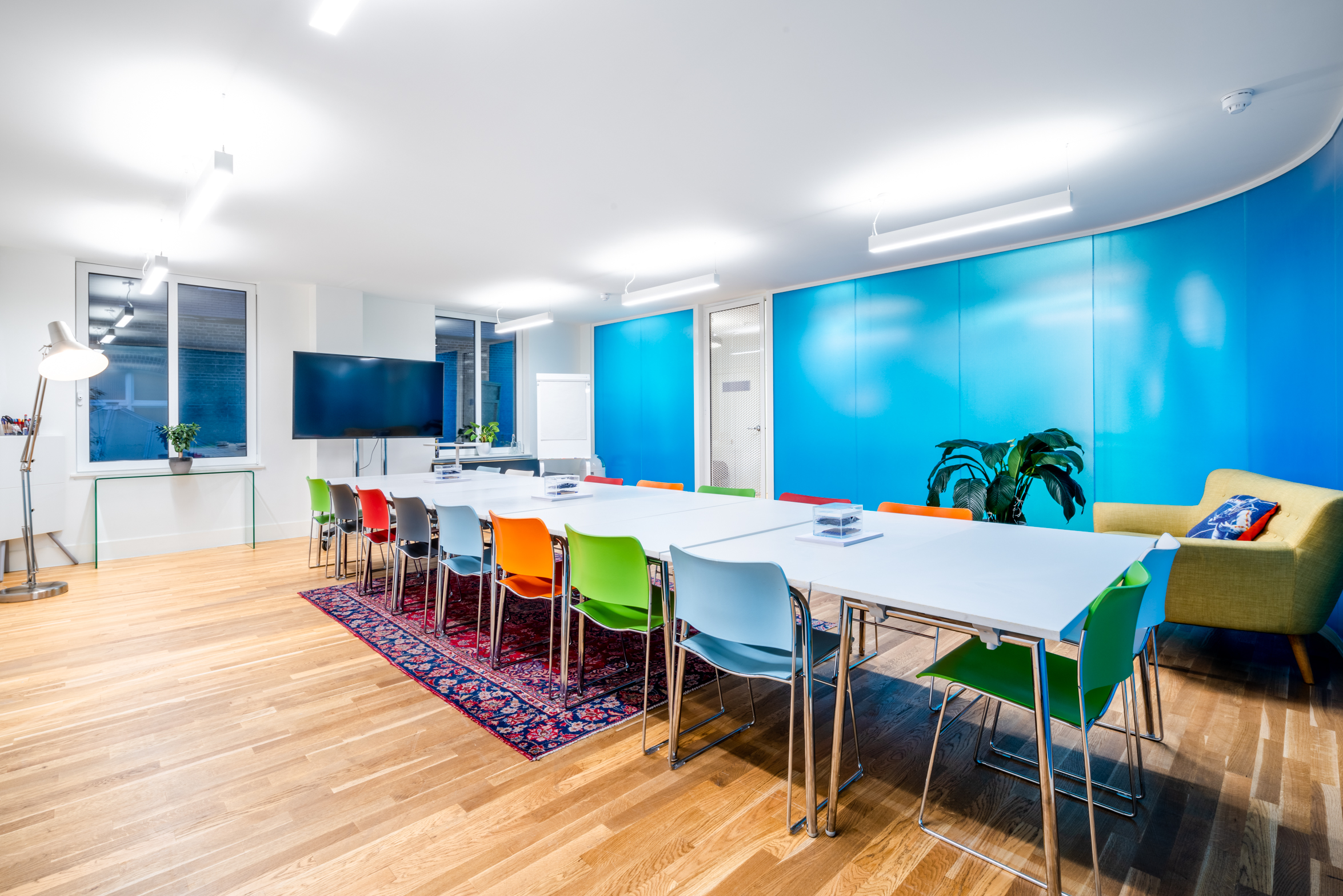 Modern meeting room with colorful chairs, ideal for collaborative events and brainstorming.