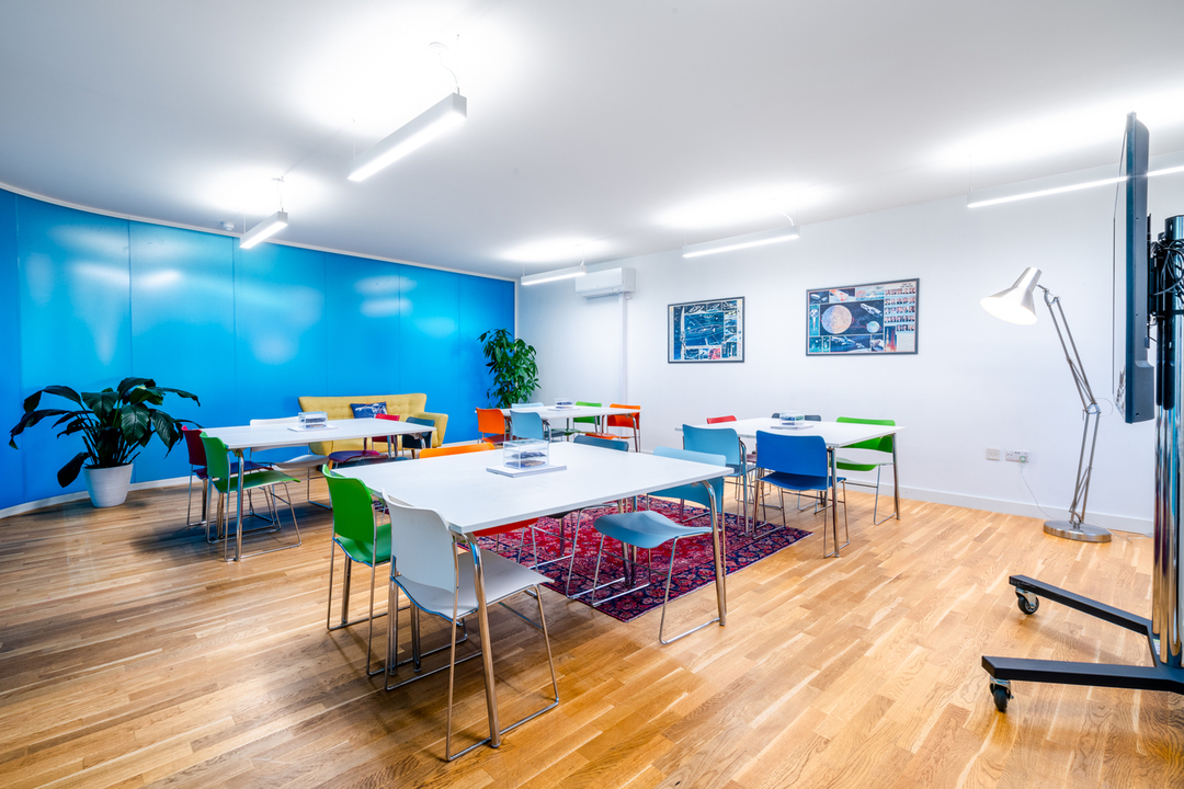 Modern meeting space with blue accent wall, ideal for workshops and brainstorming sessions.