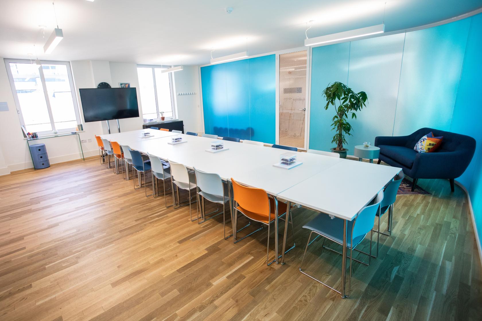 Valentina in a vibrant modern meeting room with colorful chairs at Wallacespace Spitalfields.