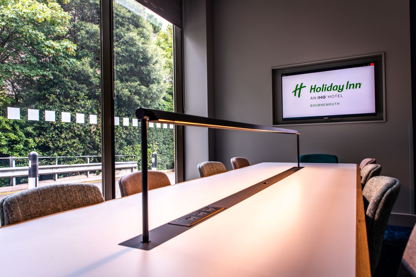 Modern meeting room at Holiday Inn Bournemouth with sleek table and natural light.