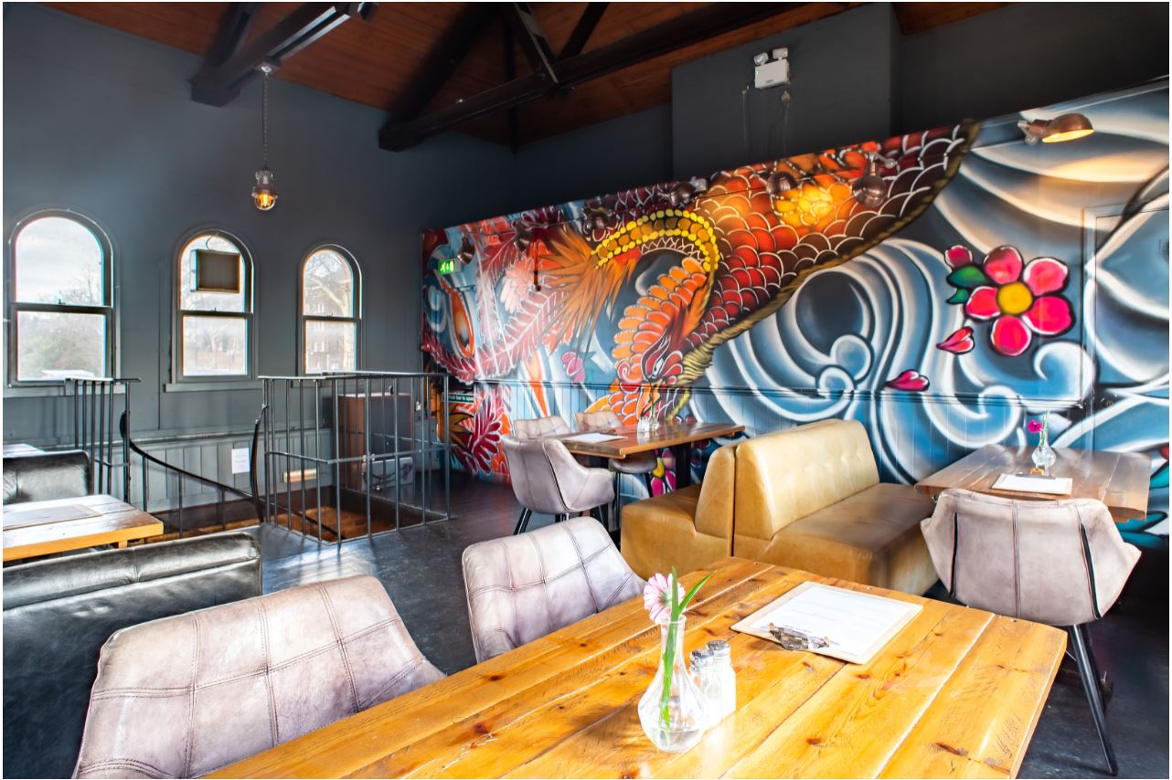 Vibrant event space at The Mezzanine, featuring a striking mural for gatherings and workshops.