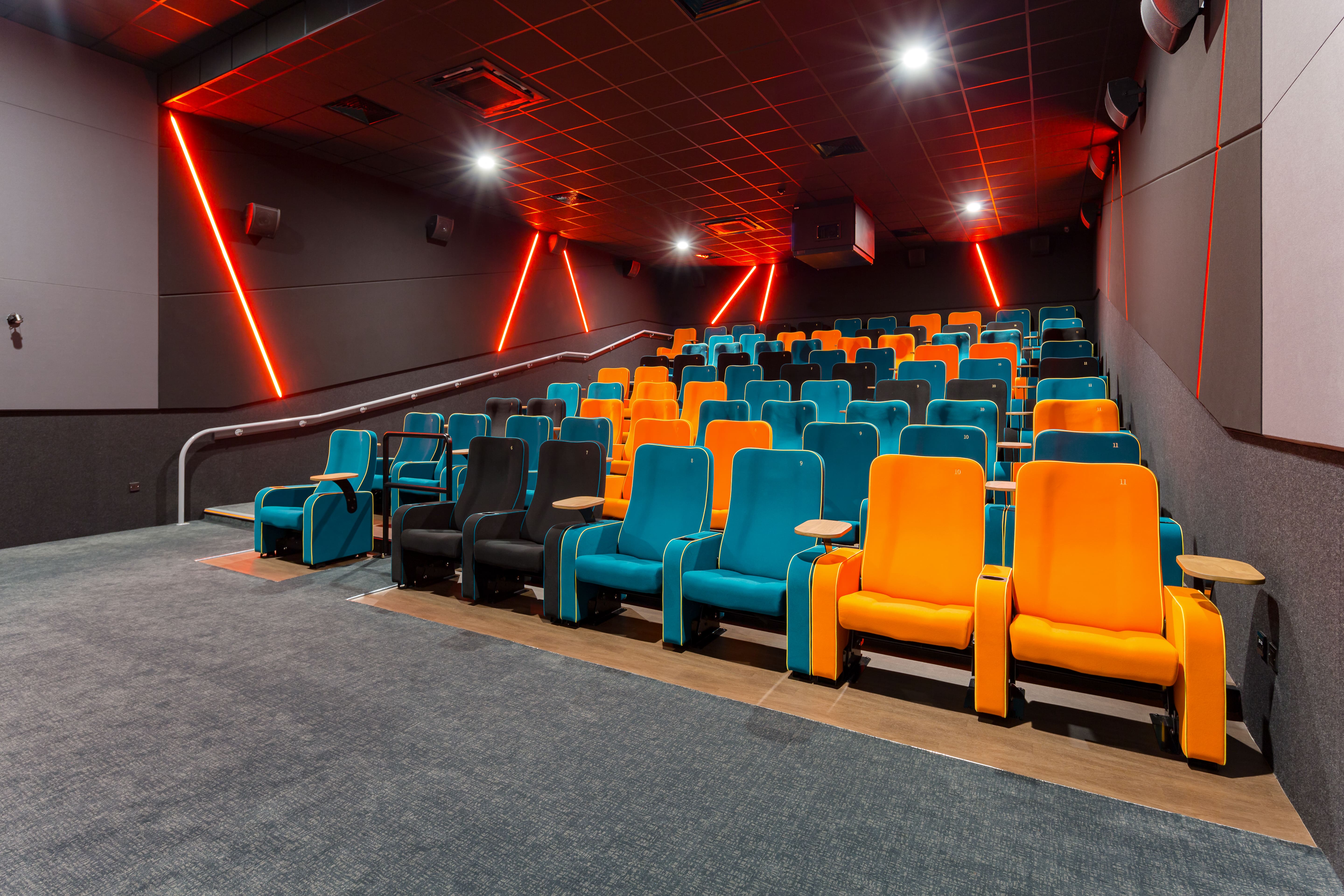 Modern cinema auditorium with teal and orange seating for engaging film screenings.