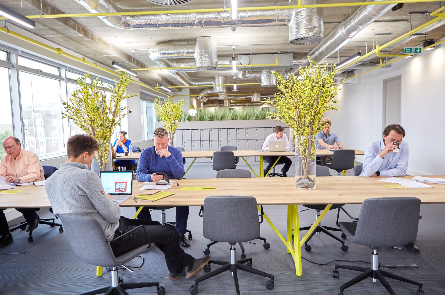 Modern open-concept workspace with communal tables for meetings and brainstorming events.