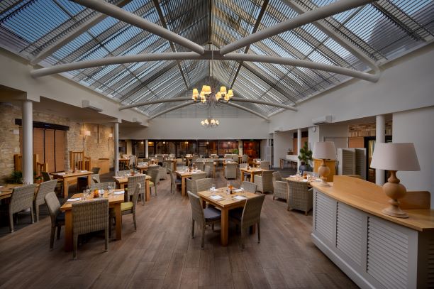 Spacious dining area with glass ceiling at voco™ Oxford Thames Hotel for events.