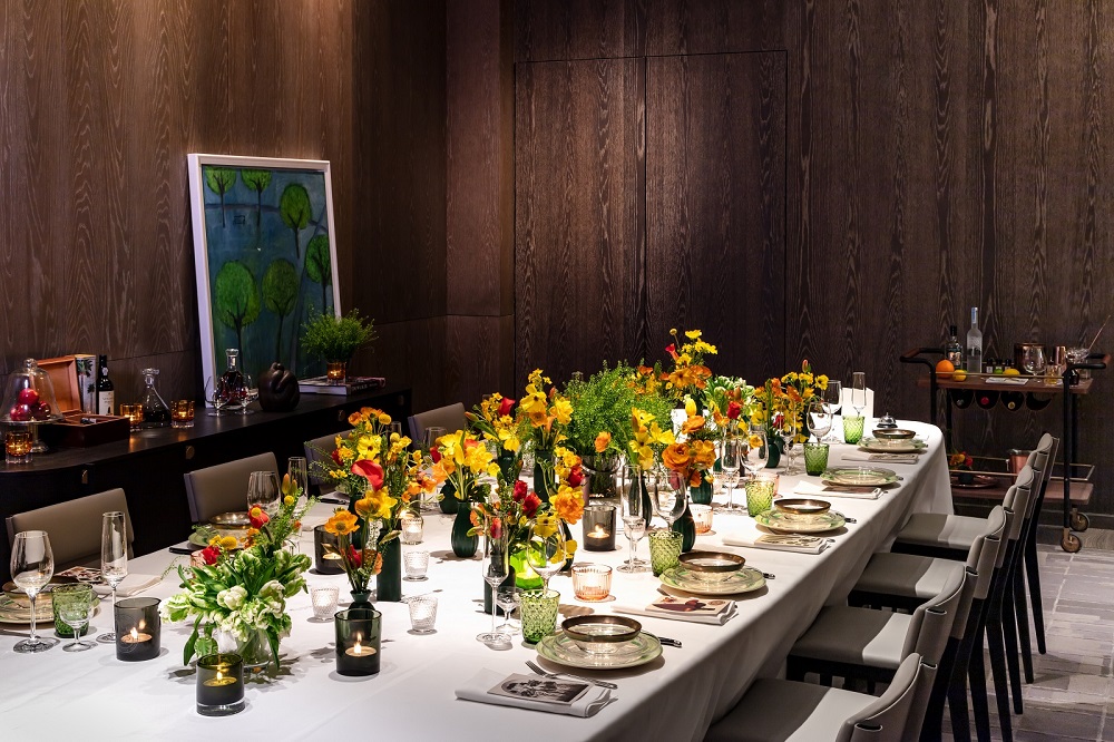 Elegant dining table with floral centerpieces for corporate dinner in cozy London venue.