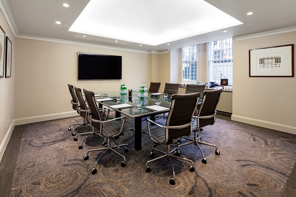 Modern conference room with glass table at Radisson Blu Hotel, ideal for corporate events.