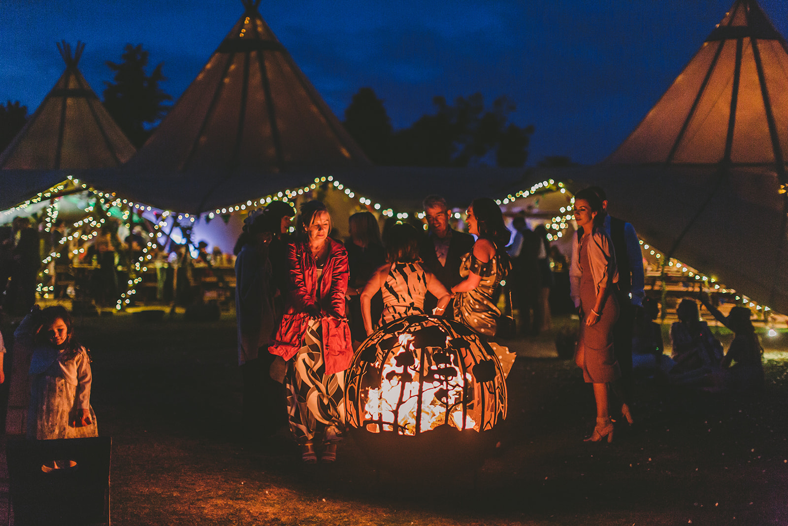 Vibrant outdoor event at Vanstone Park with illuminated tents and cozy fire pits.