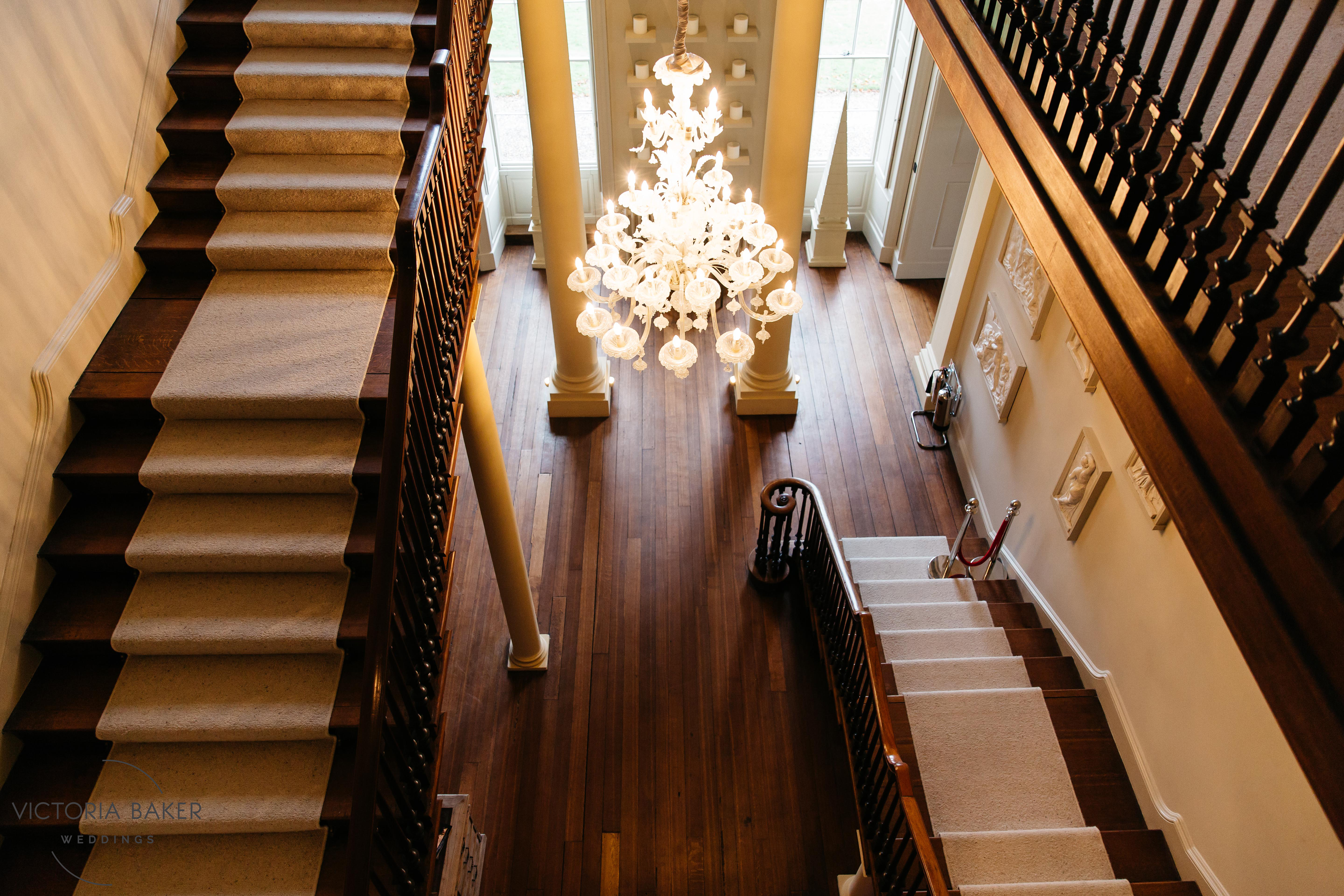 Elegant Howsham Hall venue with grand staircase and chandelier for events and meetings.