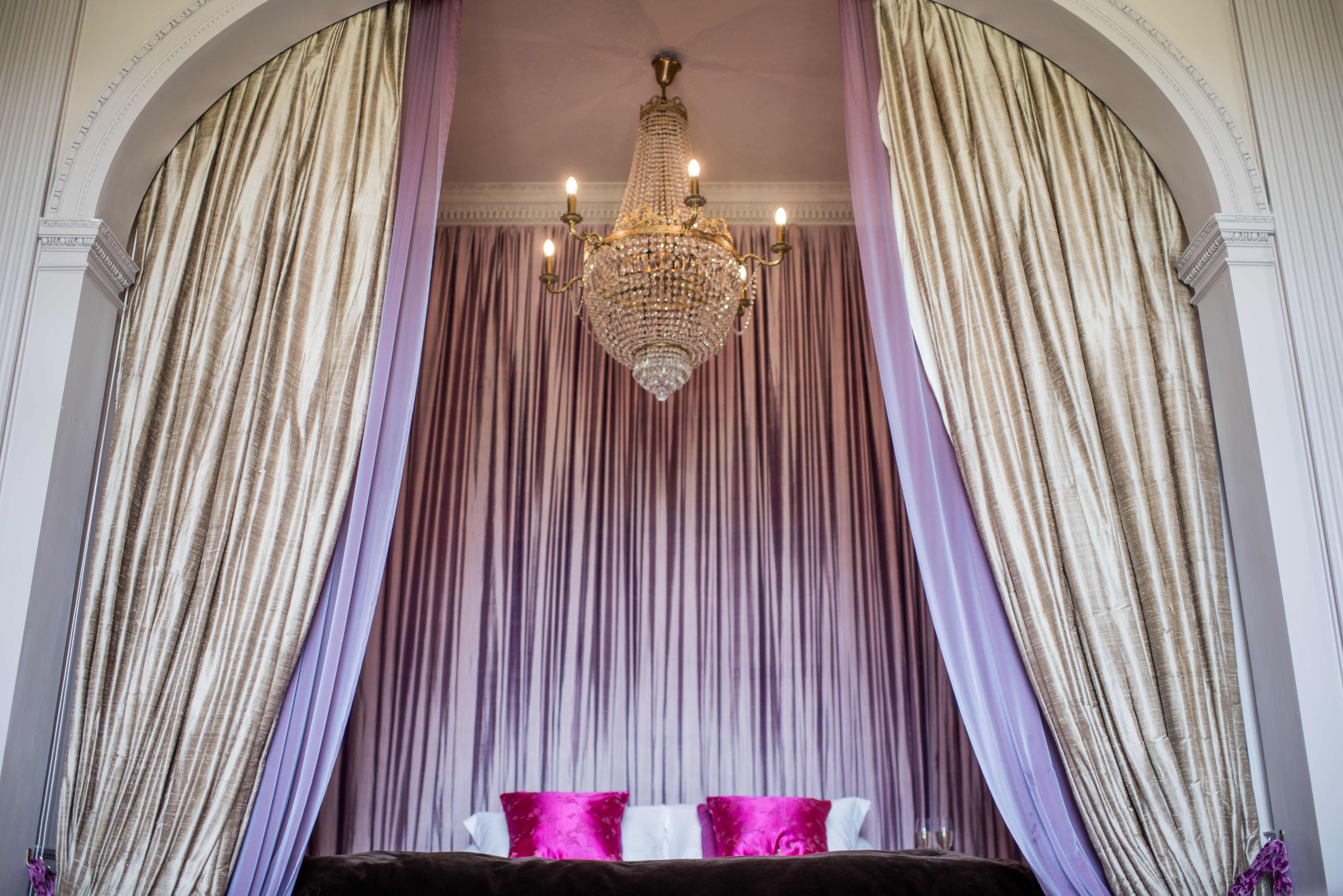 Elegant event space in Howsham Hall with luxurious drapery and chandelier for gatherings.