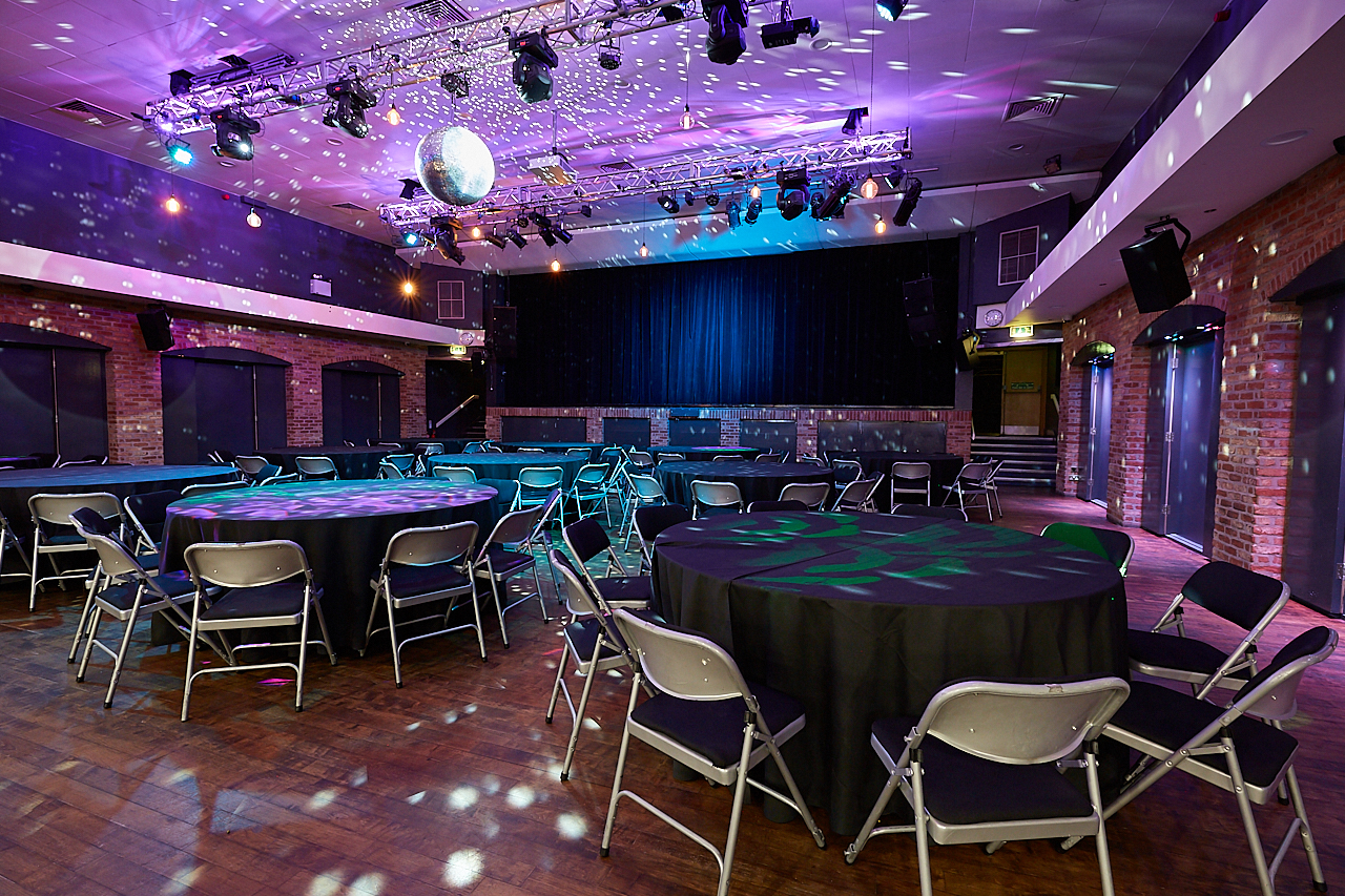 Rustic brick event venue with stage, disco ball, corporate gala, party