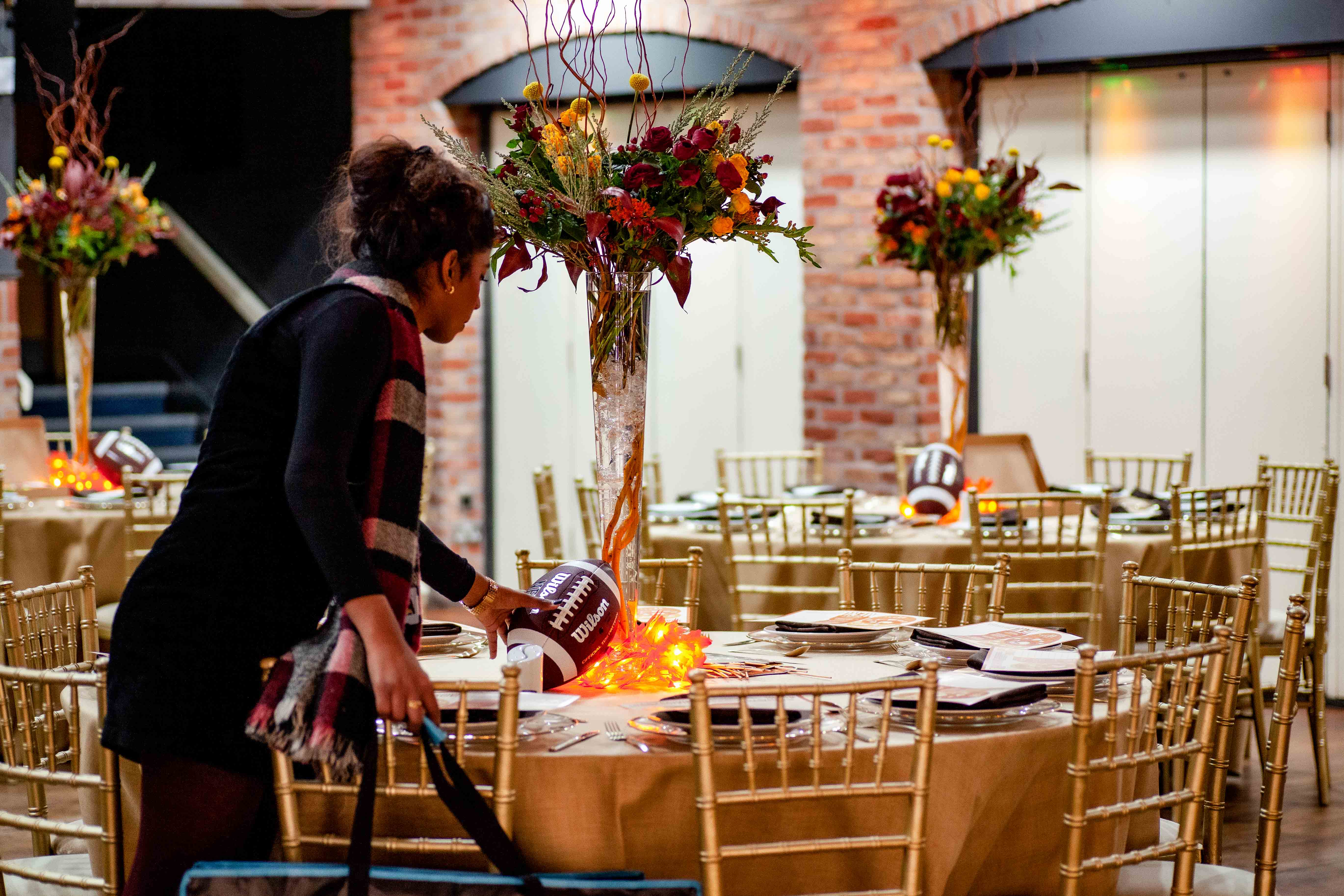 Elegant event setup: autumn florals, gold chairs, wedding venue