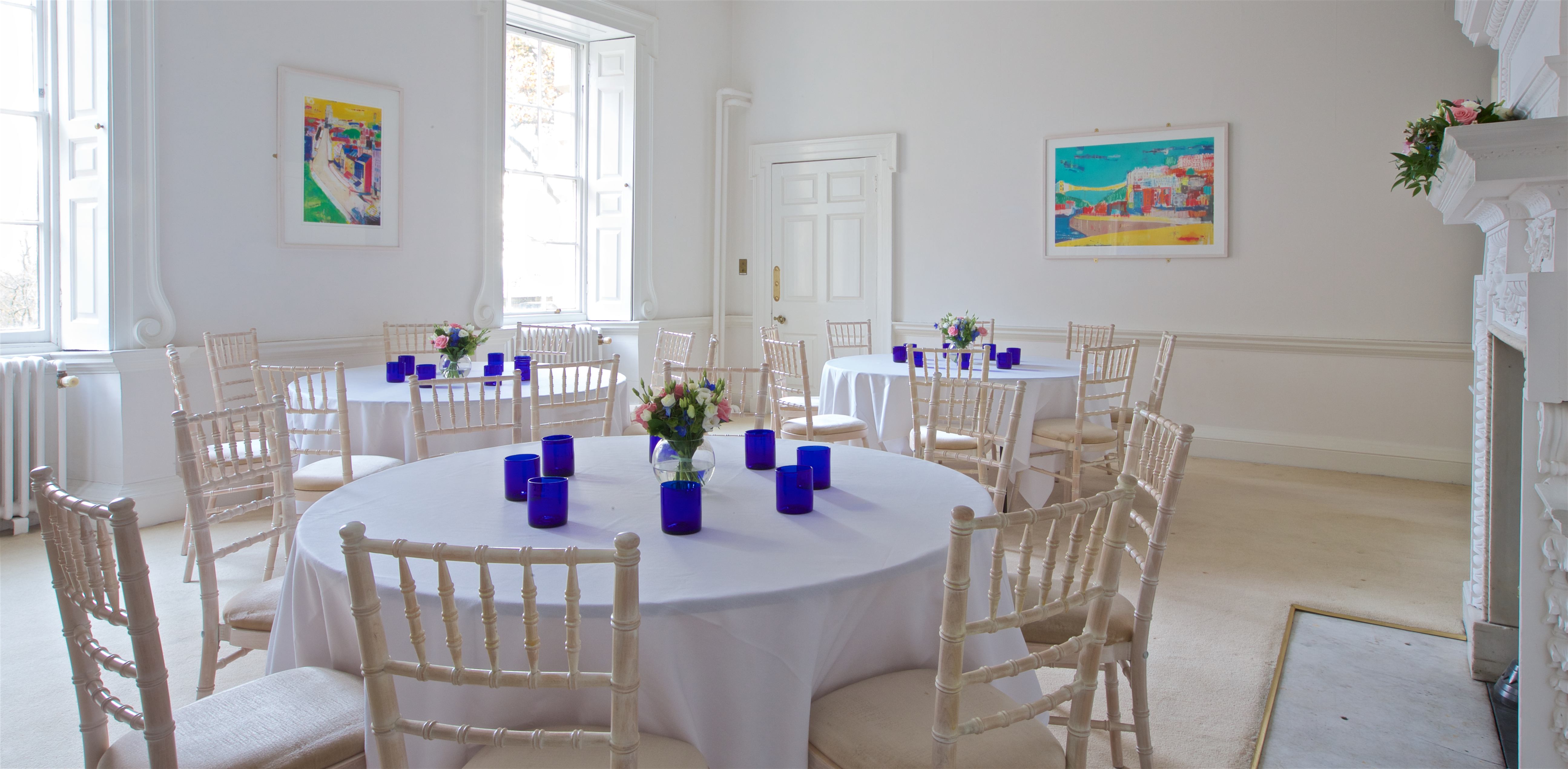 Elegant event space at Clifton Hill House with round tables and floral centerpieces.