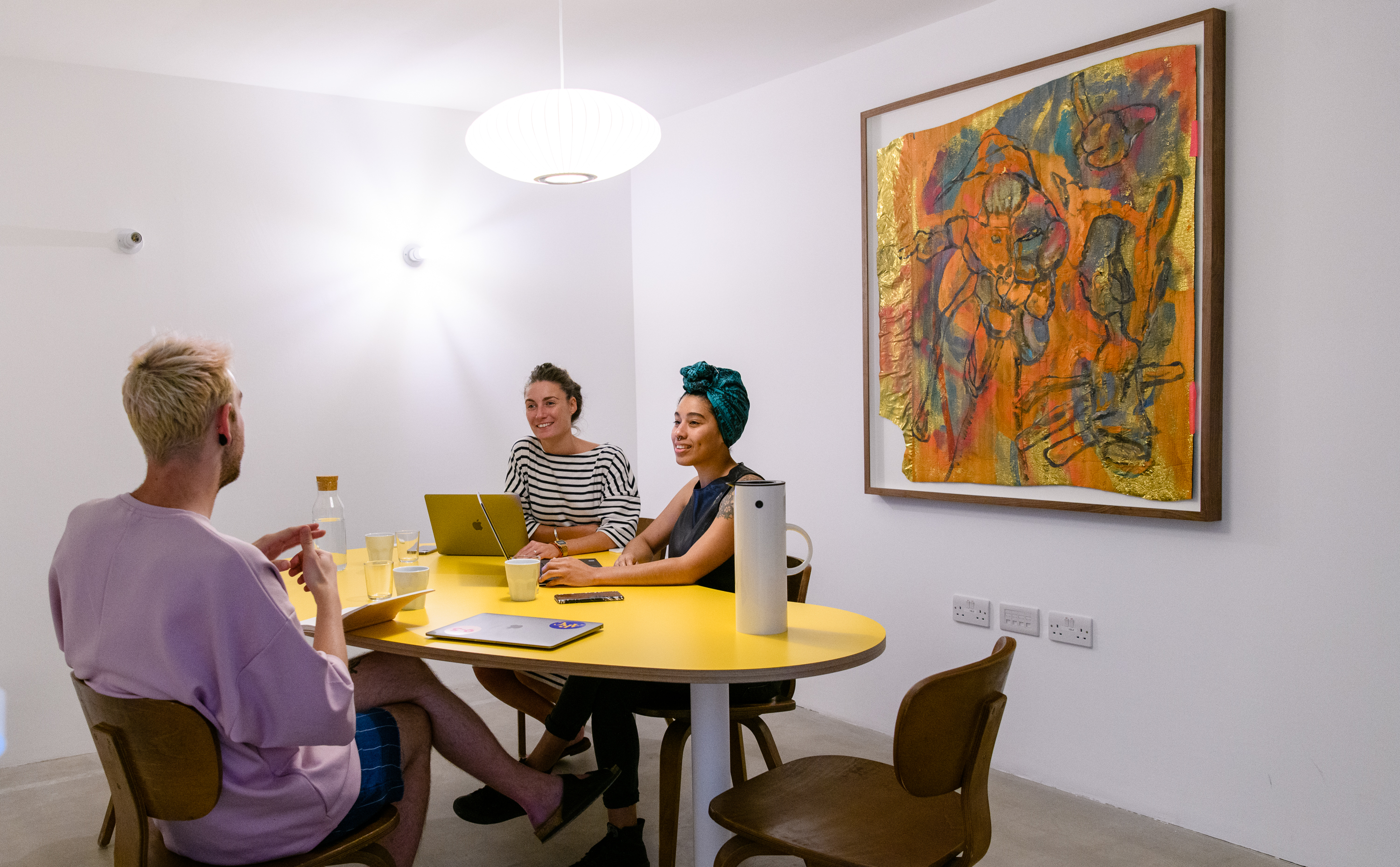 Modern meeting space with vibrant yellow table for creative collaboration at Arc Club.