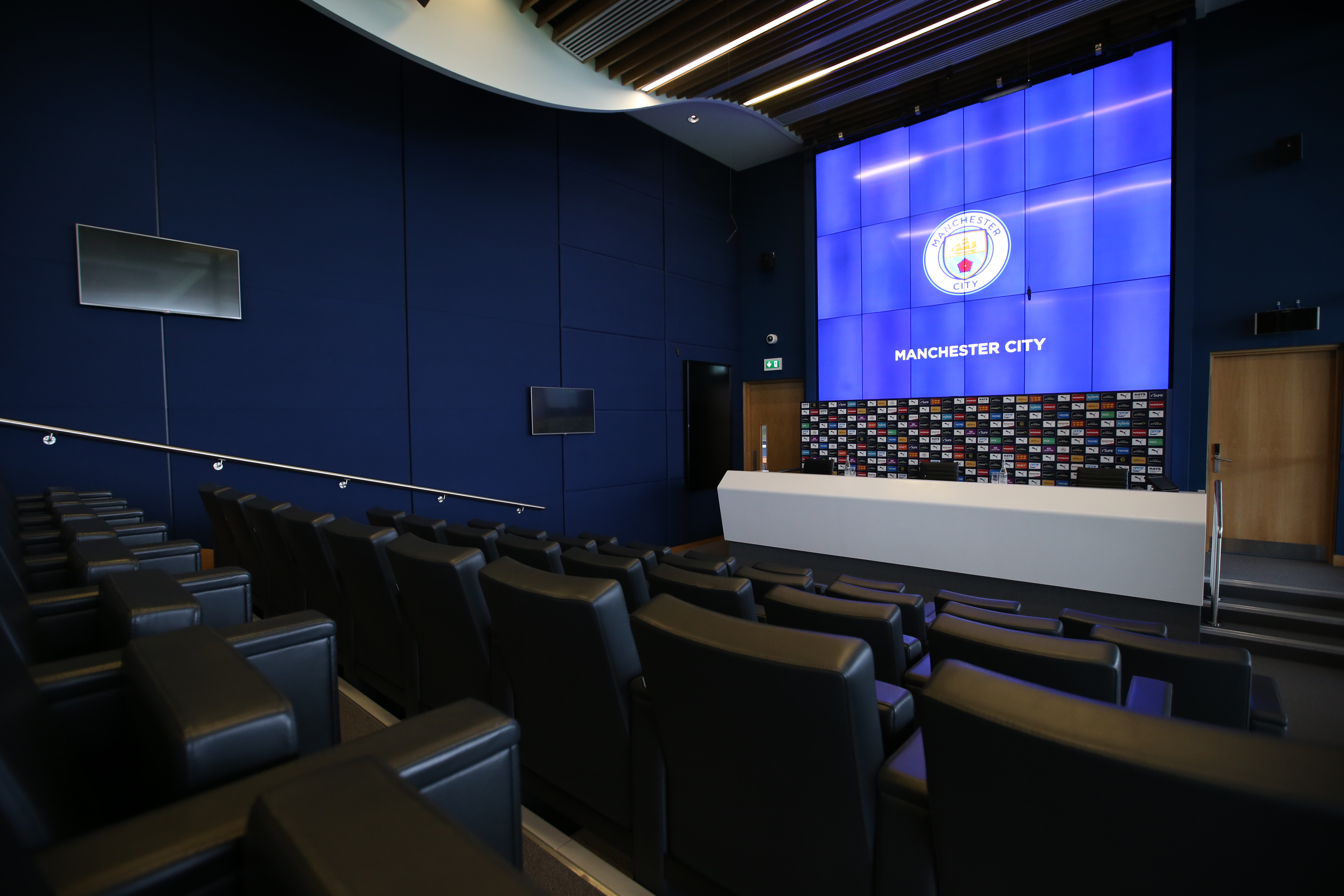 Modern conference room at City Football Academy with tiered seating for press events.
