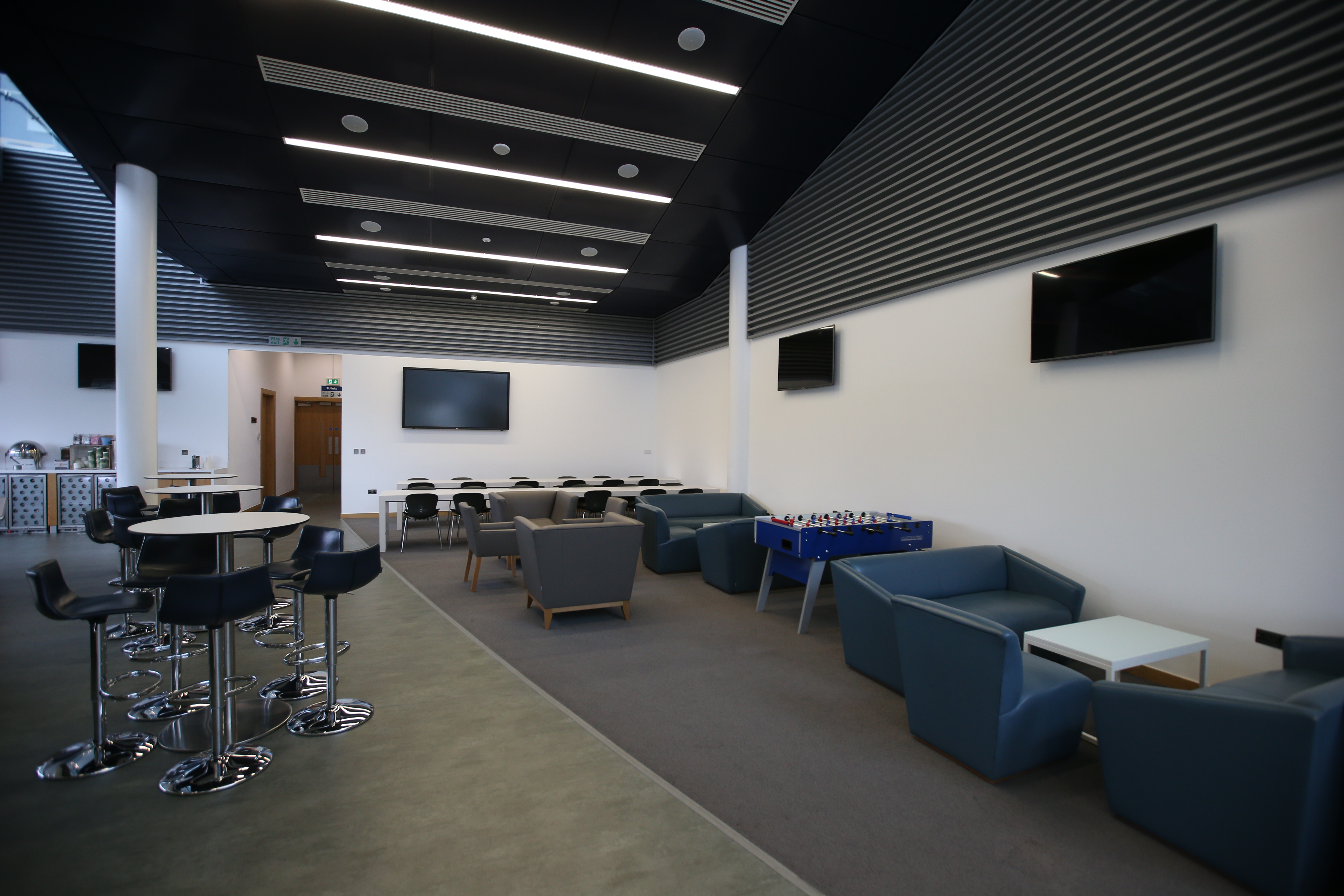 Modern event space at City Football Academy, featuring sleek furniture for networking.