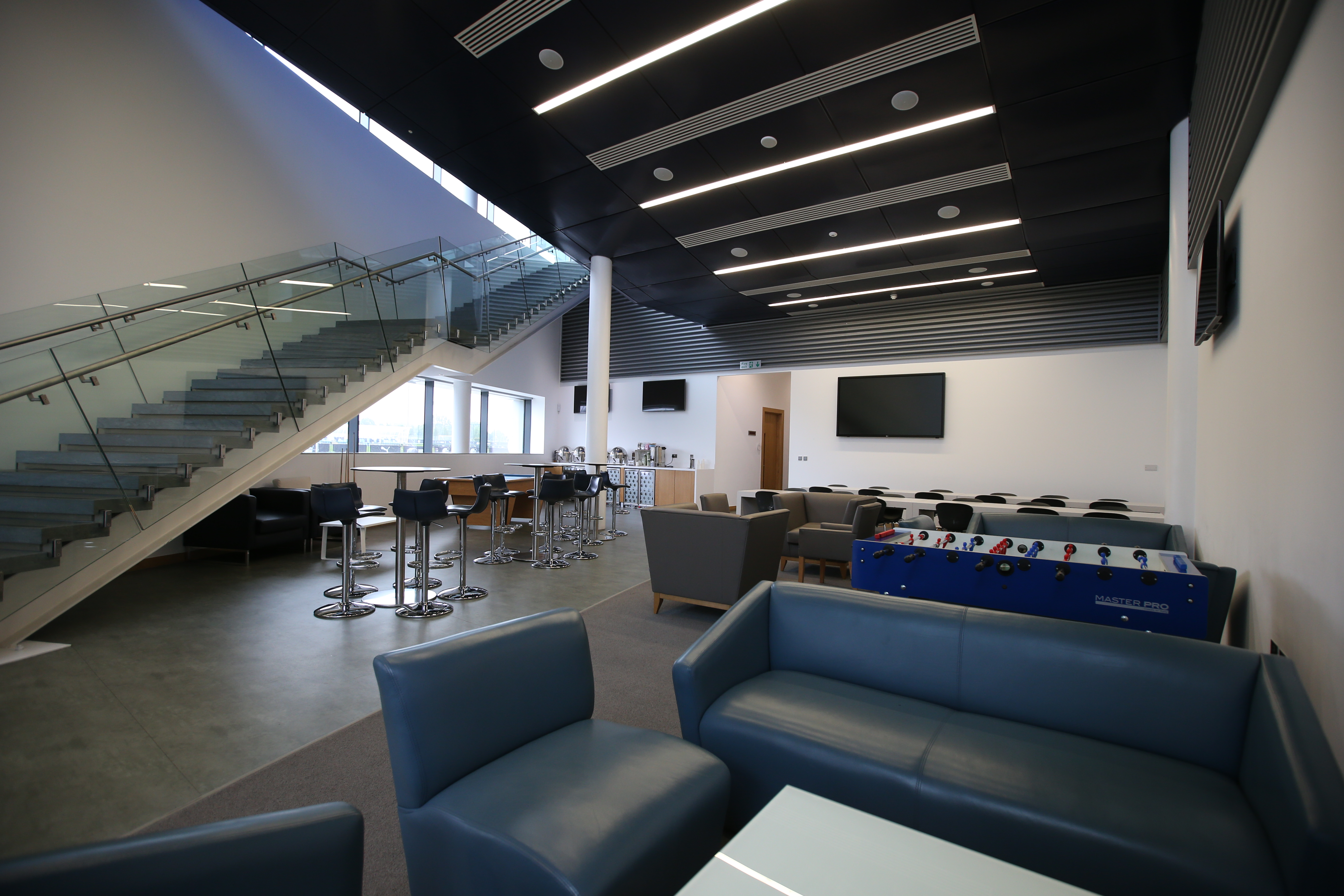 Modern event space with lounge seating at City Football Academy for networking and workshops.