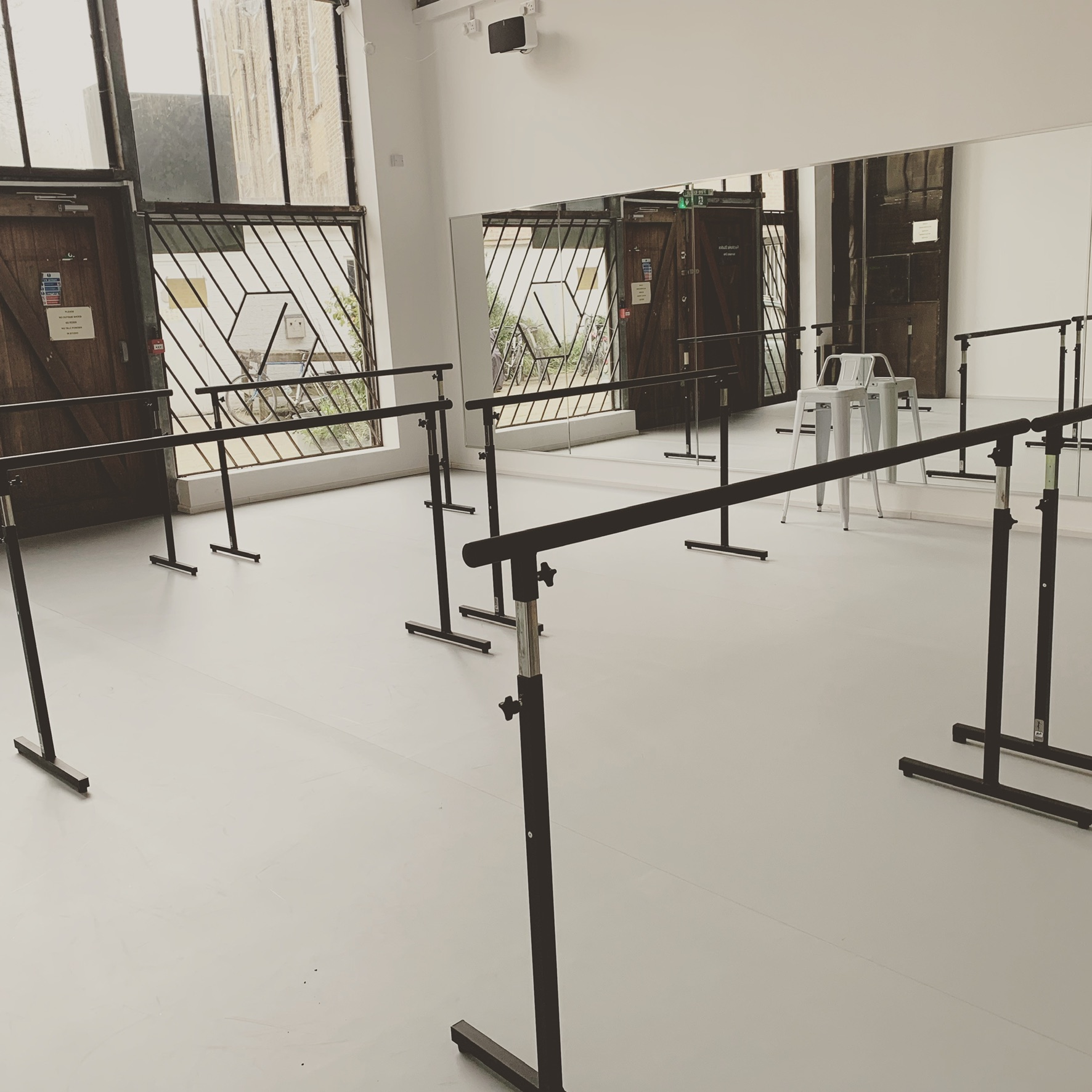 Versatile dance venue with ballet barres, ideal for workshops and fitness classes.