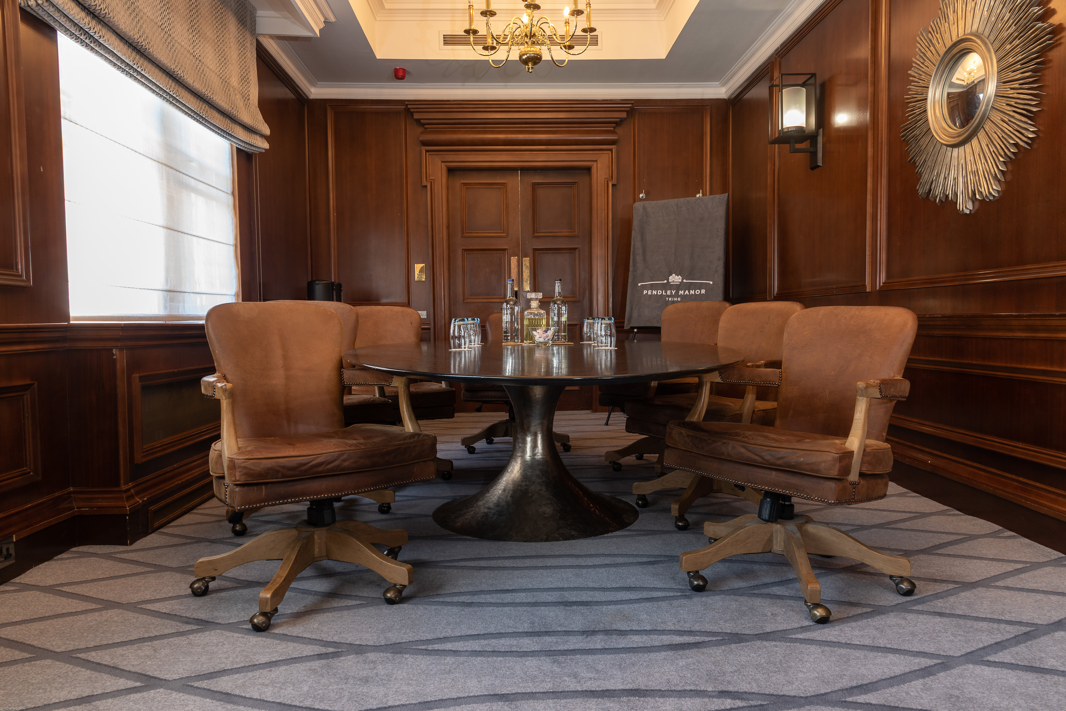 Sophisticated meeting room in Pendley Manor with warm wood paneling, ideal for conferences.