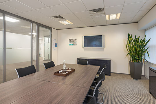 Modern conference room with wooden table, ideal for professional meetings and presentations.