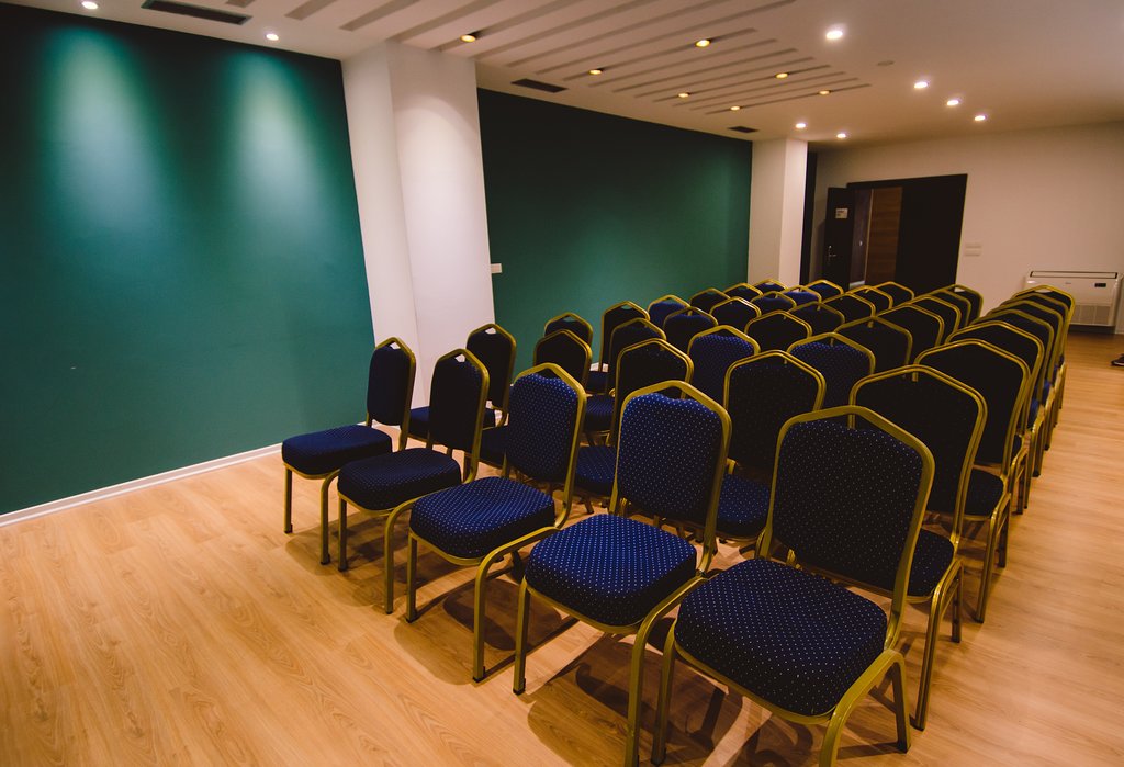 Modern meeting venue with blue chairs, perfect for presentations and workshops.