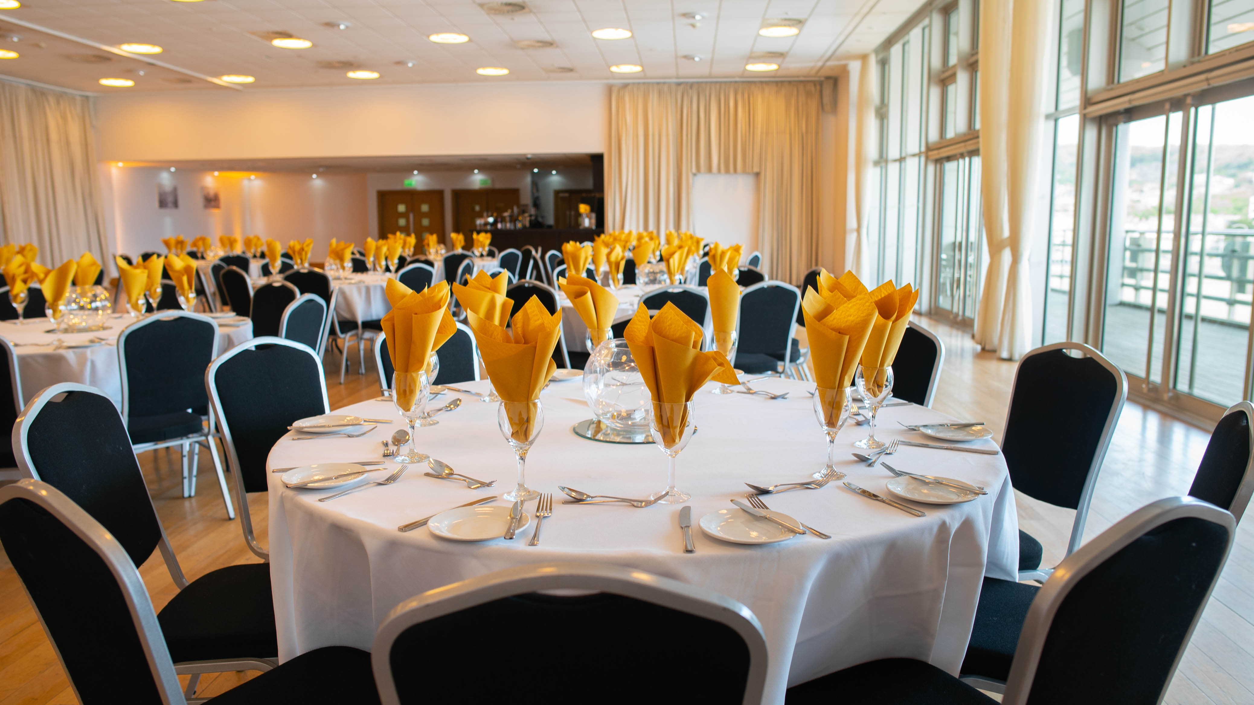 Regency Suite banquet setup with white linens and yellow napkins for corporate events.