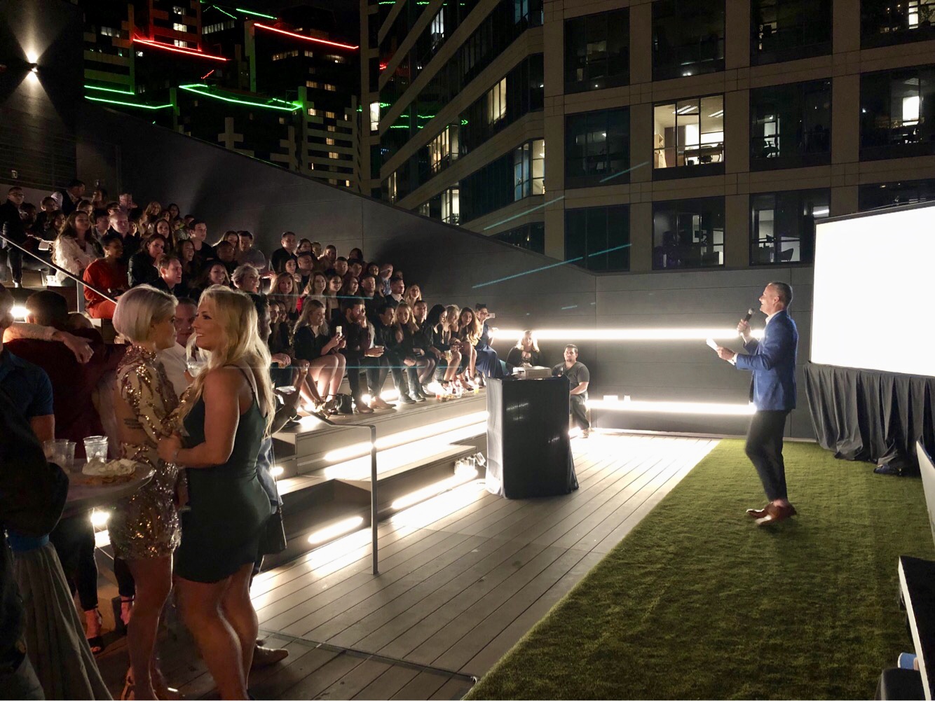 Outdoor event on Deck 655 with speaker in blue suit, ideal for networking and engagement.