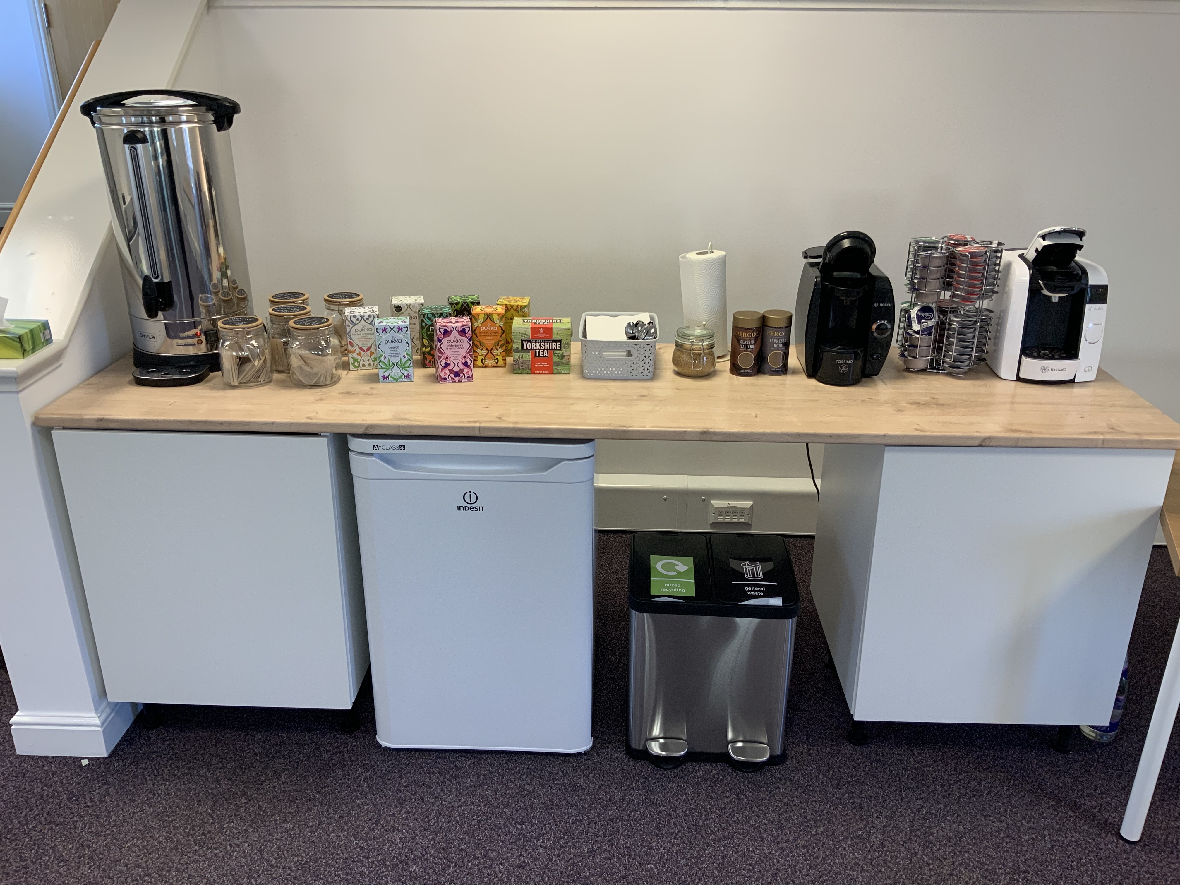 Conference room refreshment station with coffee, tea, and chilled drinks for events.