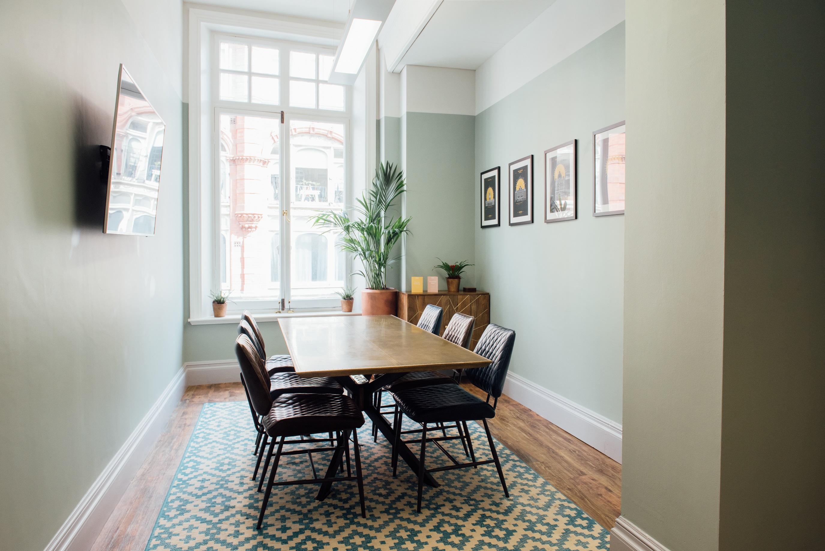 "Modern meeting room with large table and greenery for team brainstorming sessions"