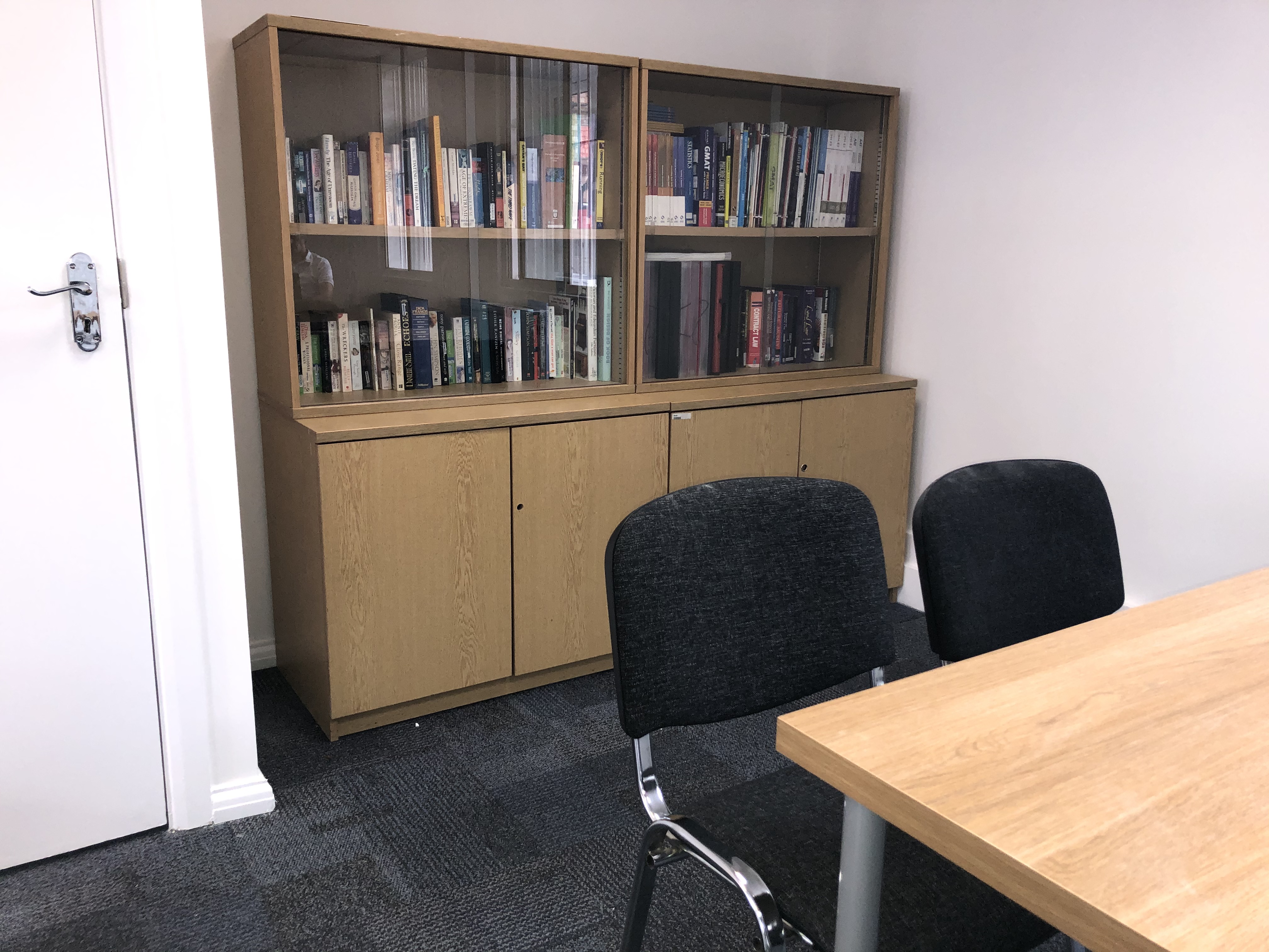 Seminar room with wooden table and black chairs for leadership discussions and workshops.